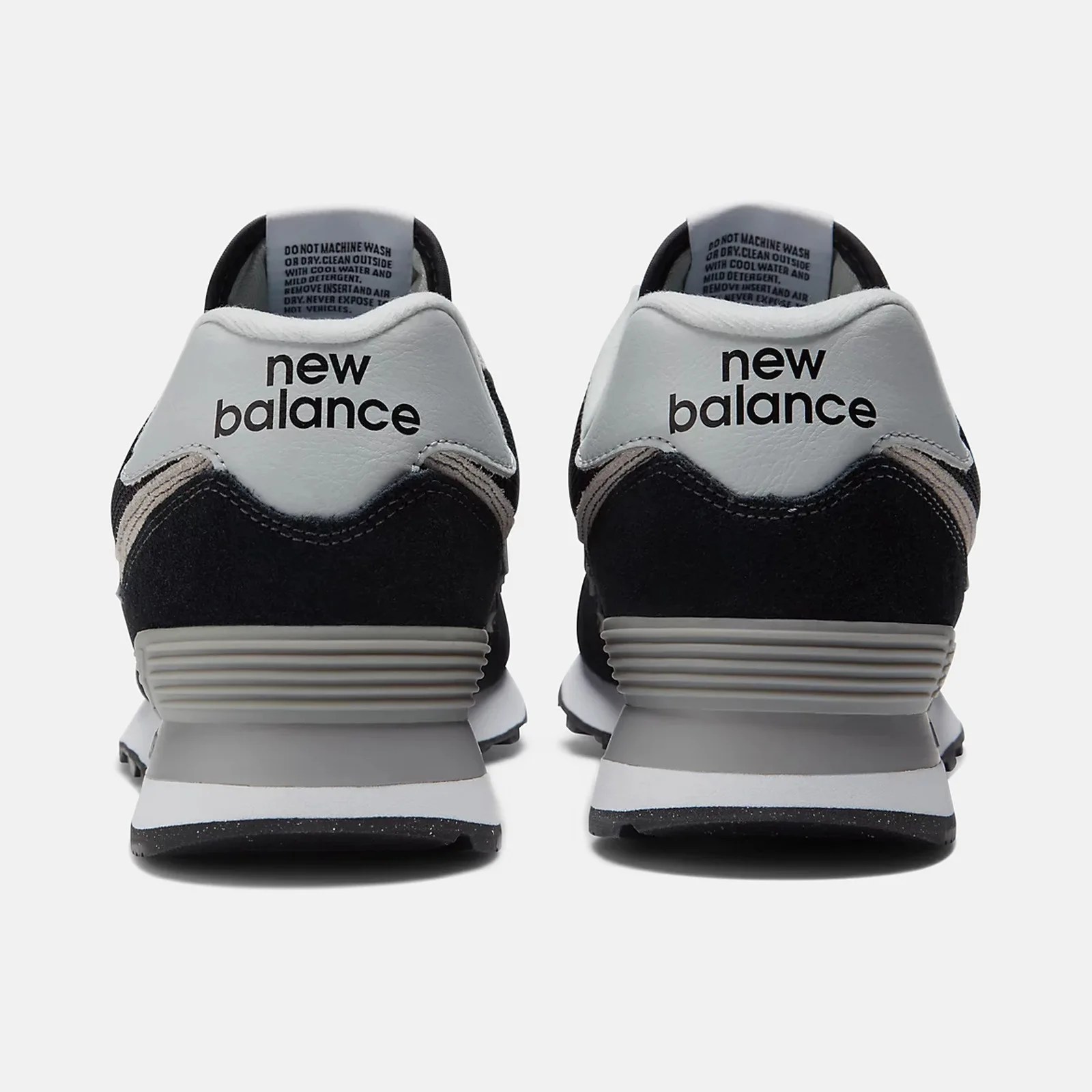 Pair of black and white New Balance sneakers shown from the back with "new balance" text on the heel tab.