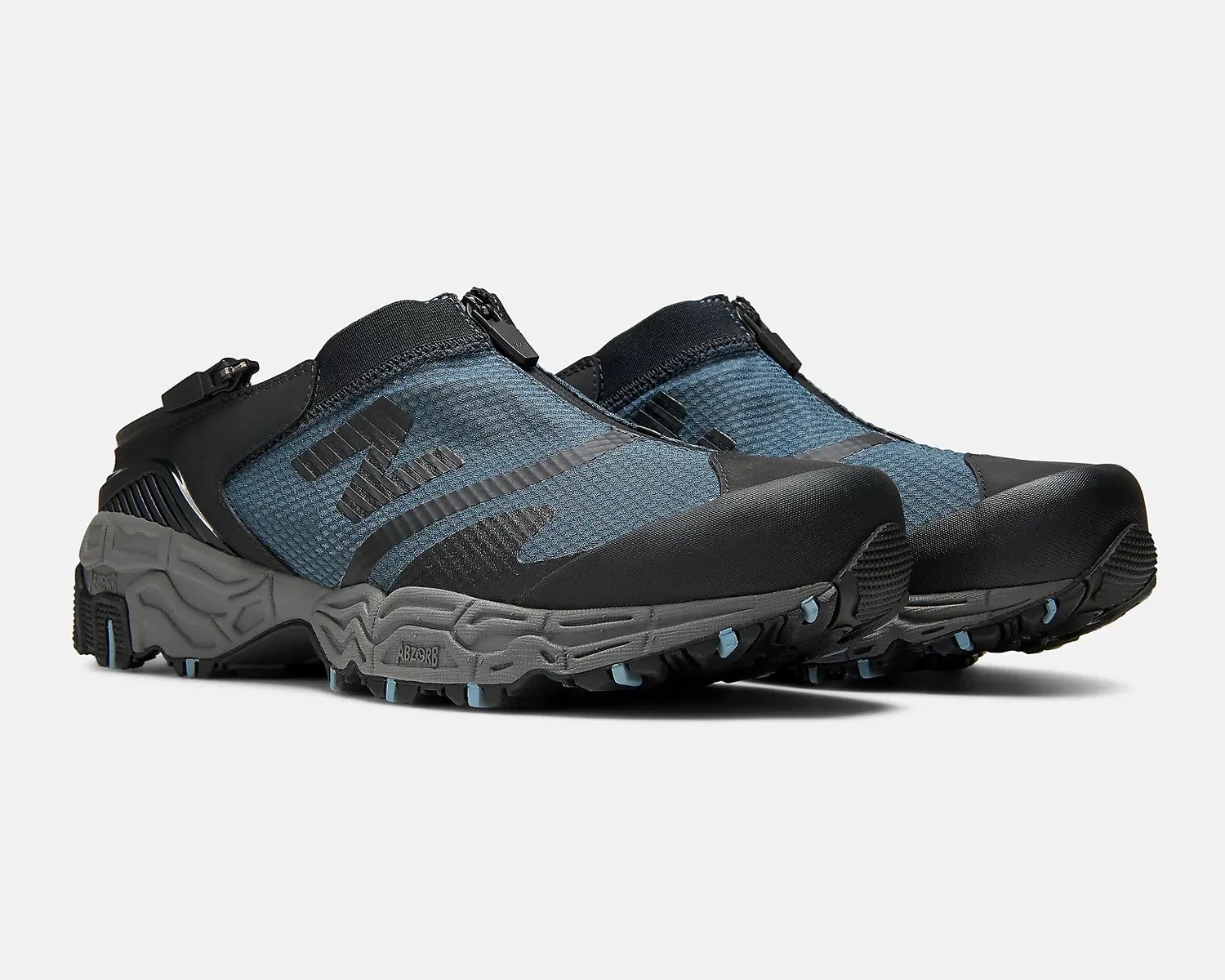 Pair of blue and black New Balance trail running shoes with gray soles and zipper closures.