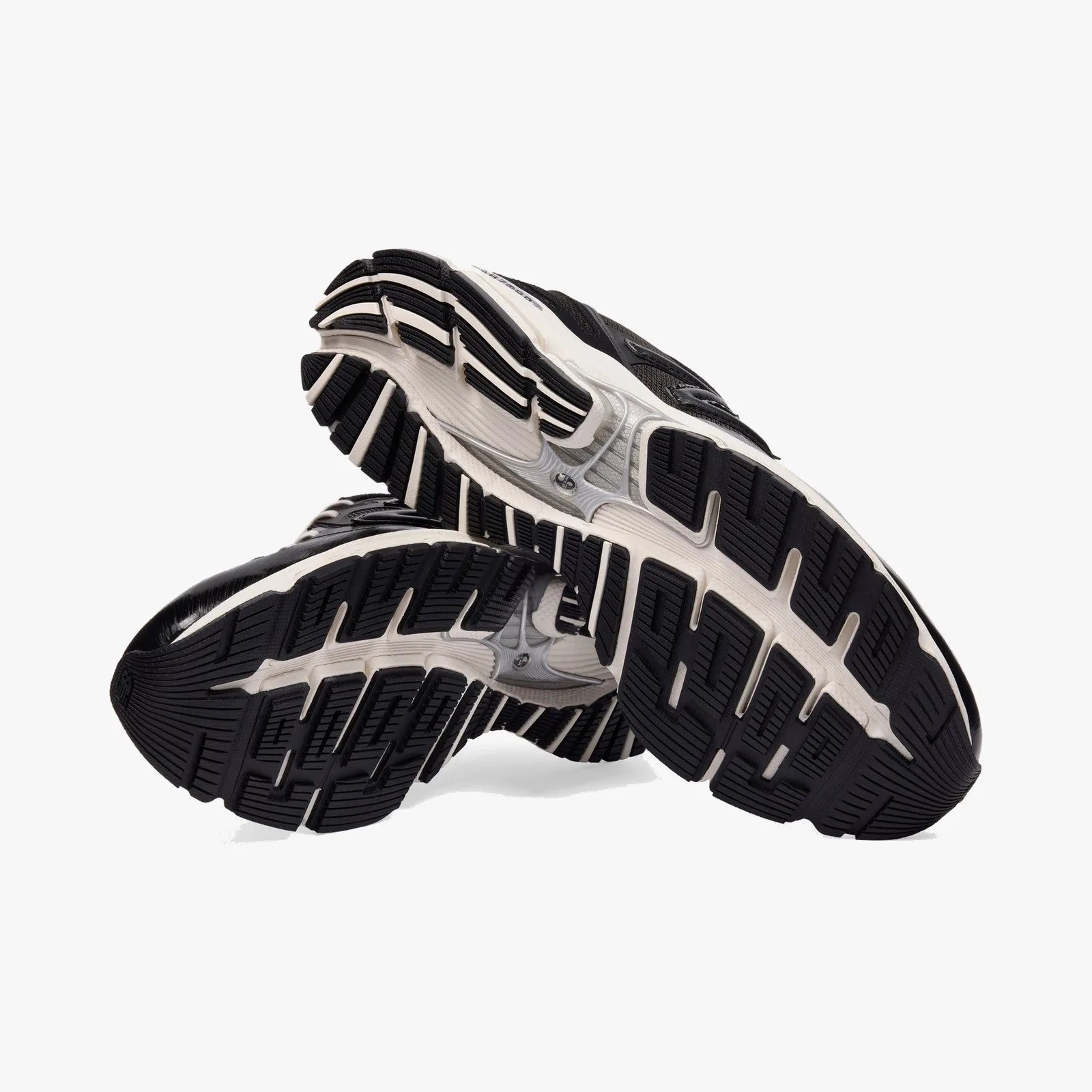 Black and white athletic shoe soles with textured tread pattern shown from below.