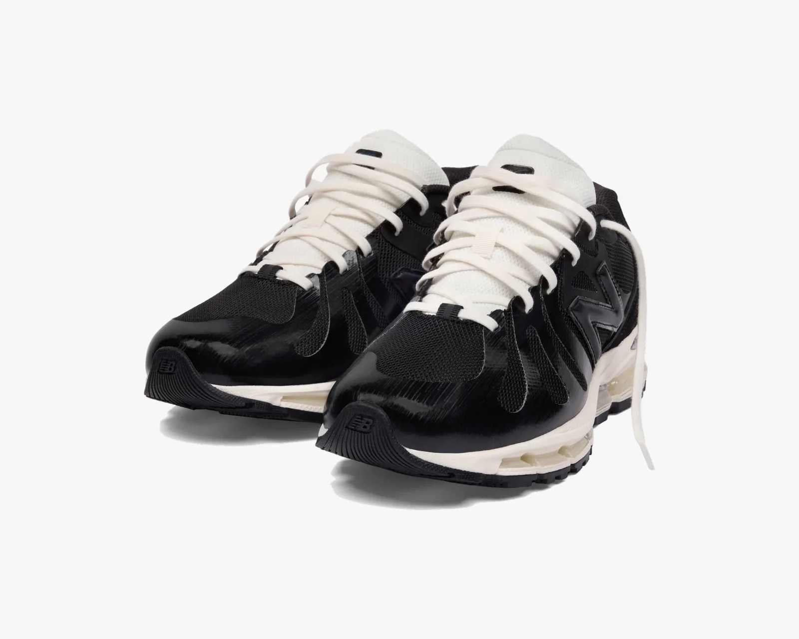 Pair of black and white New Balance athletic shoes with white laces and cushioned soles.