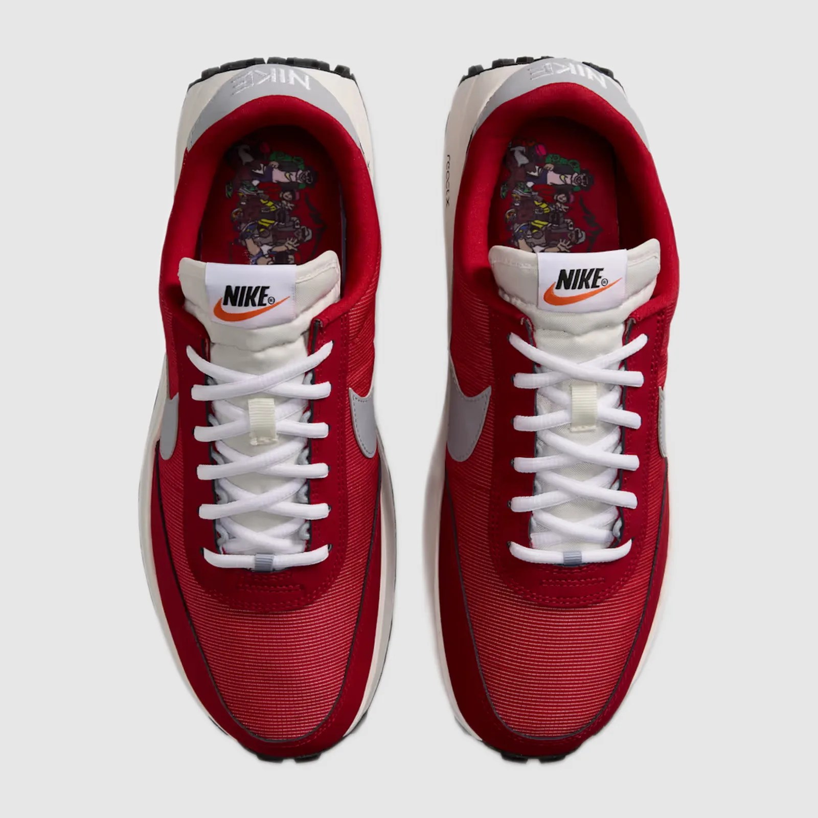 Pair of red and white Nike sneakers with white laces and graphic insoles viewed from above.