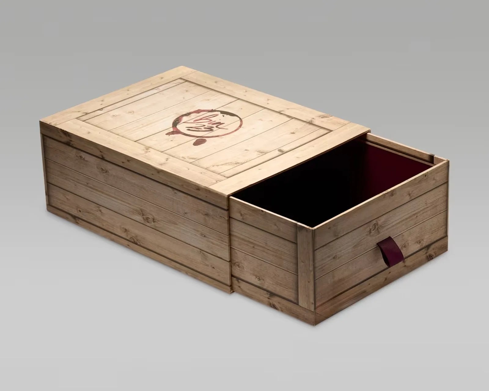 Rectangular wooden box with a sliding drawer partially open, featuring a maroon fabric pull tab and a circular logo on the top.