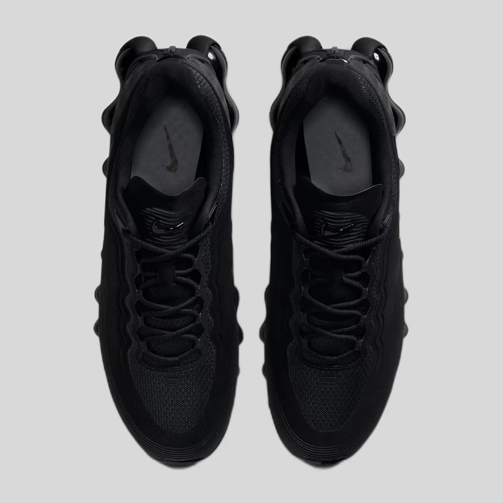 Pair of black Nike sneakers with visible Nike logos on the insoles and tongues, viewed from above.