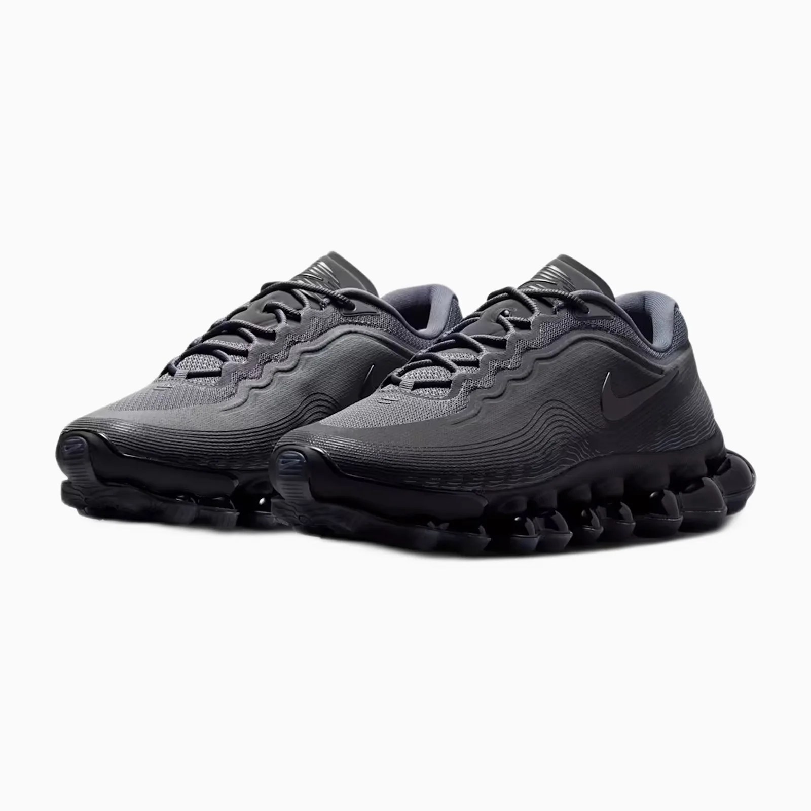 Pair of black Nike running shoes with wavy textured upper and segmented sole on a white background.
