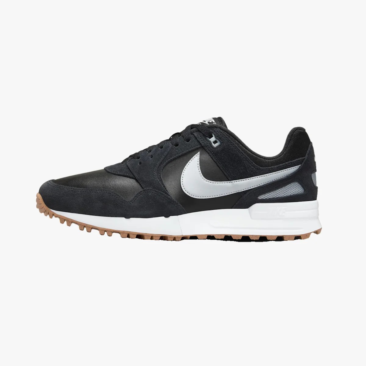 Black and white Nike sneaker with gum sole and suede overlays shown from the side.