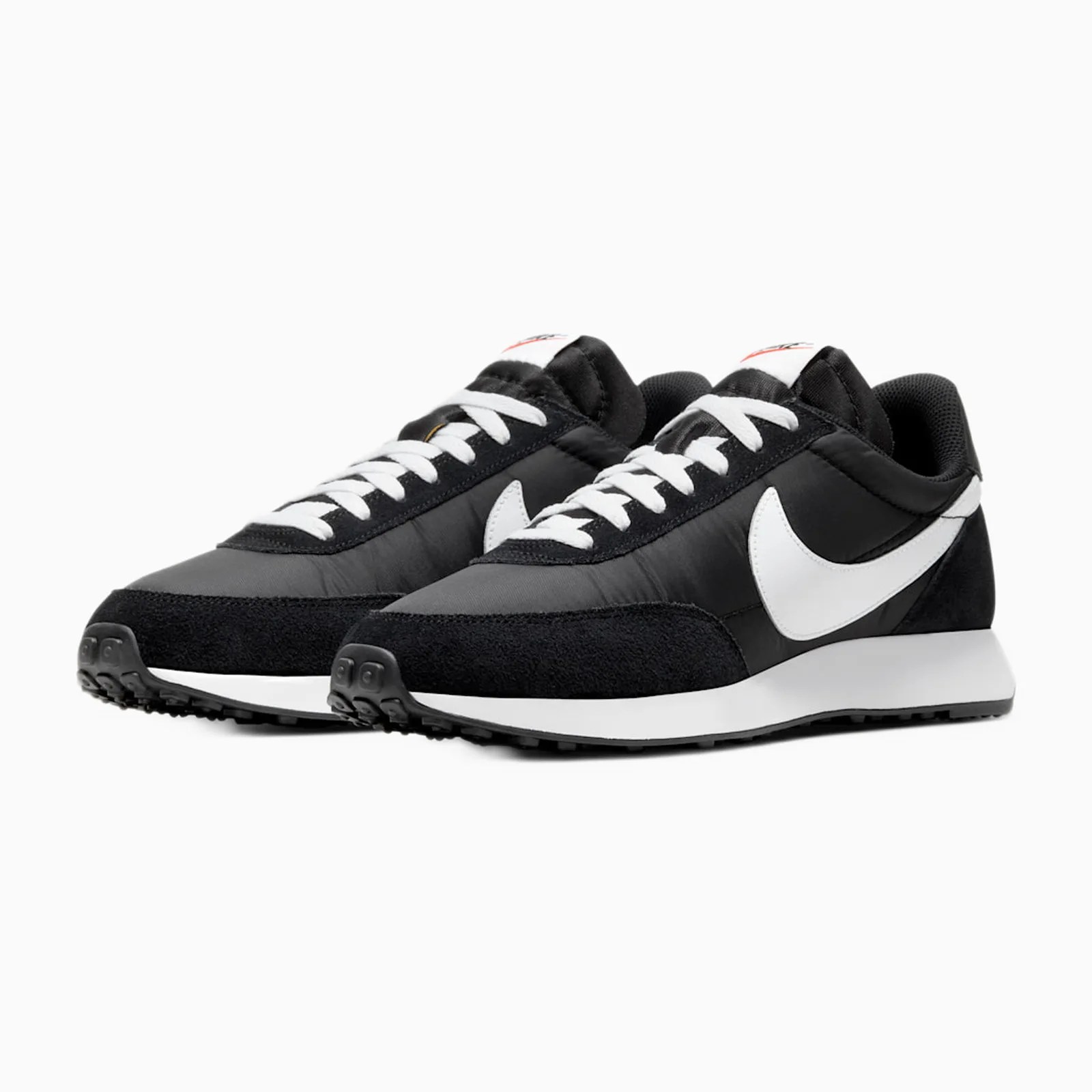 Pair of black and white Nike sneakers with white laces and a white swoosh logo on a white background.