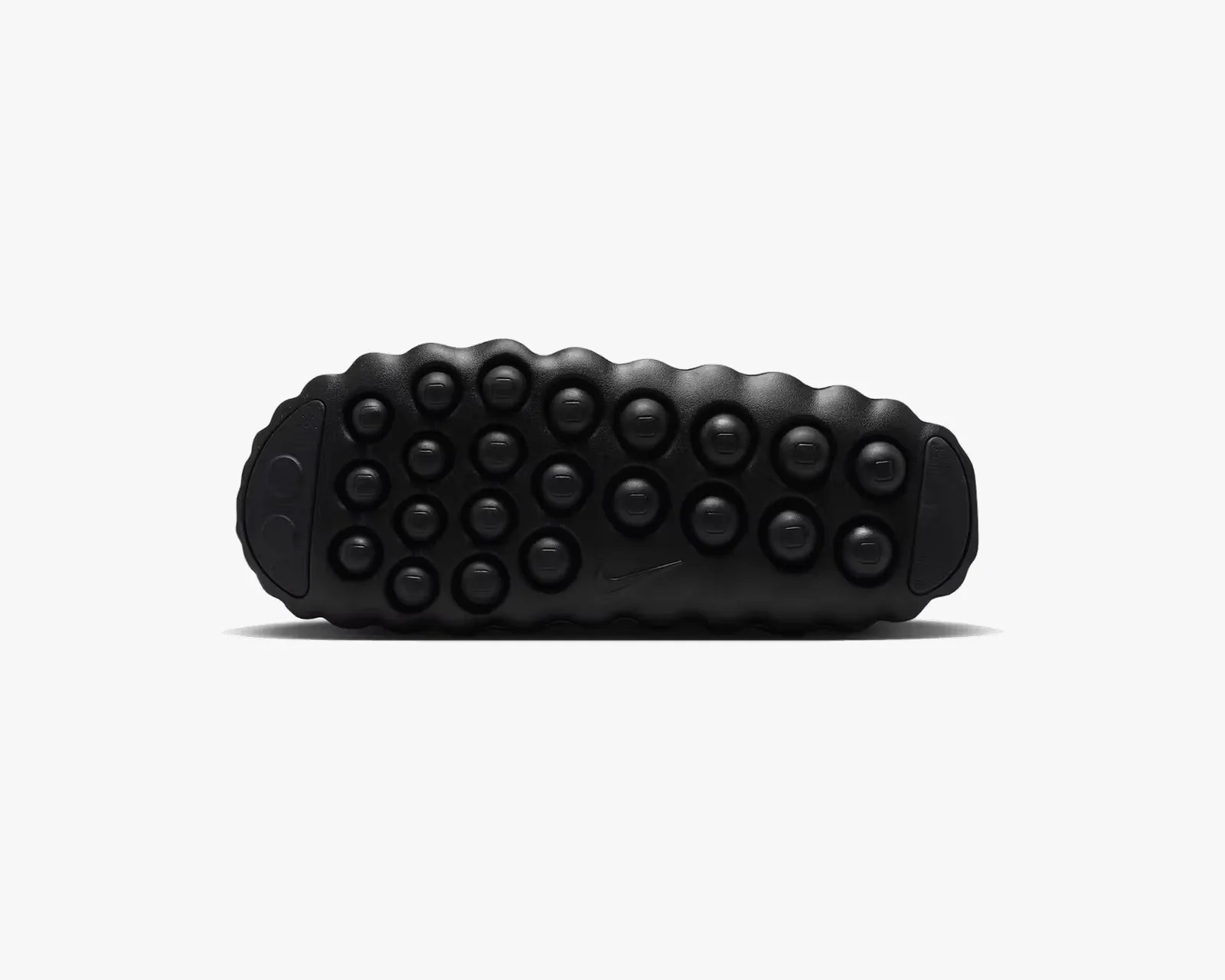 Black shoe sole with circular traction pods and a small Nike swoosh logo in the center.