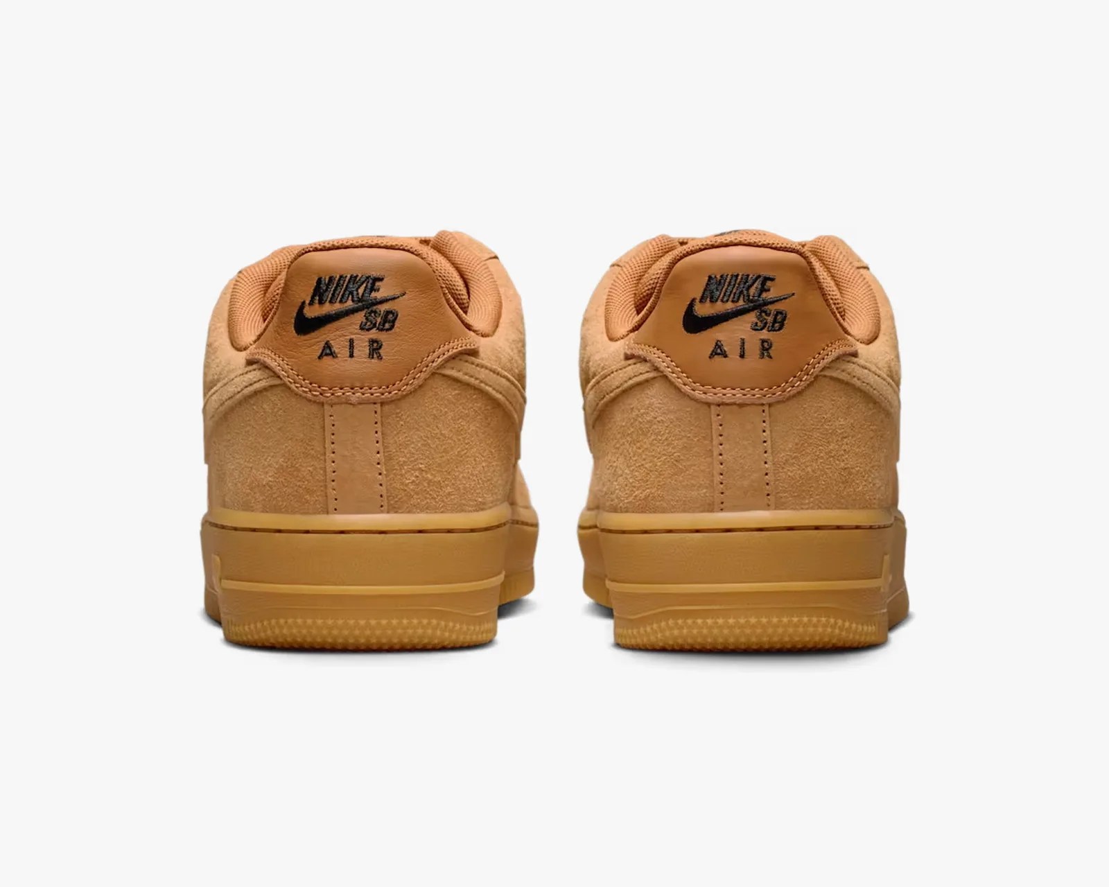 Pair of tan Nike SB Air sneakers shown from the back with black logo on the heel tab.