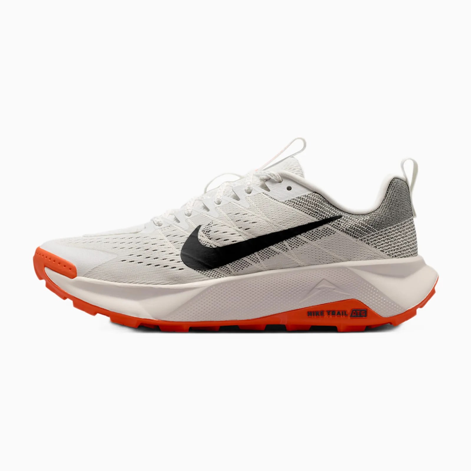 White and gray Nike trail running shoe with black swoosh and orange sole accents.