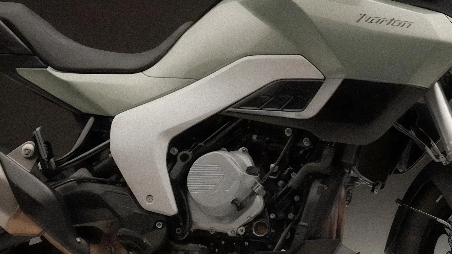 Close-up of a white and black Norton motorcycle engine and seat area.