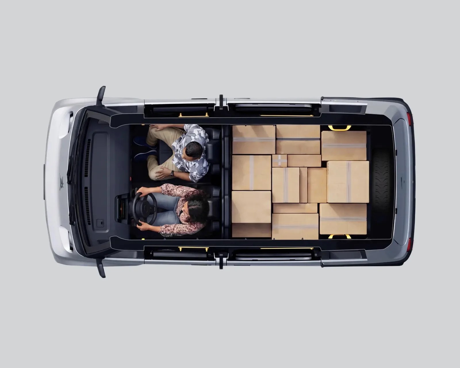 Top-down view of a silver van with two people seated in front and multiple cardboard boxes stacked in the cargo area.
