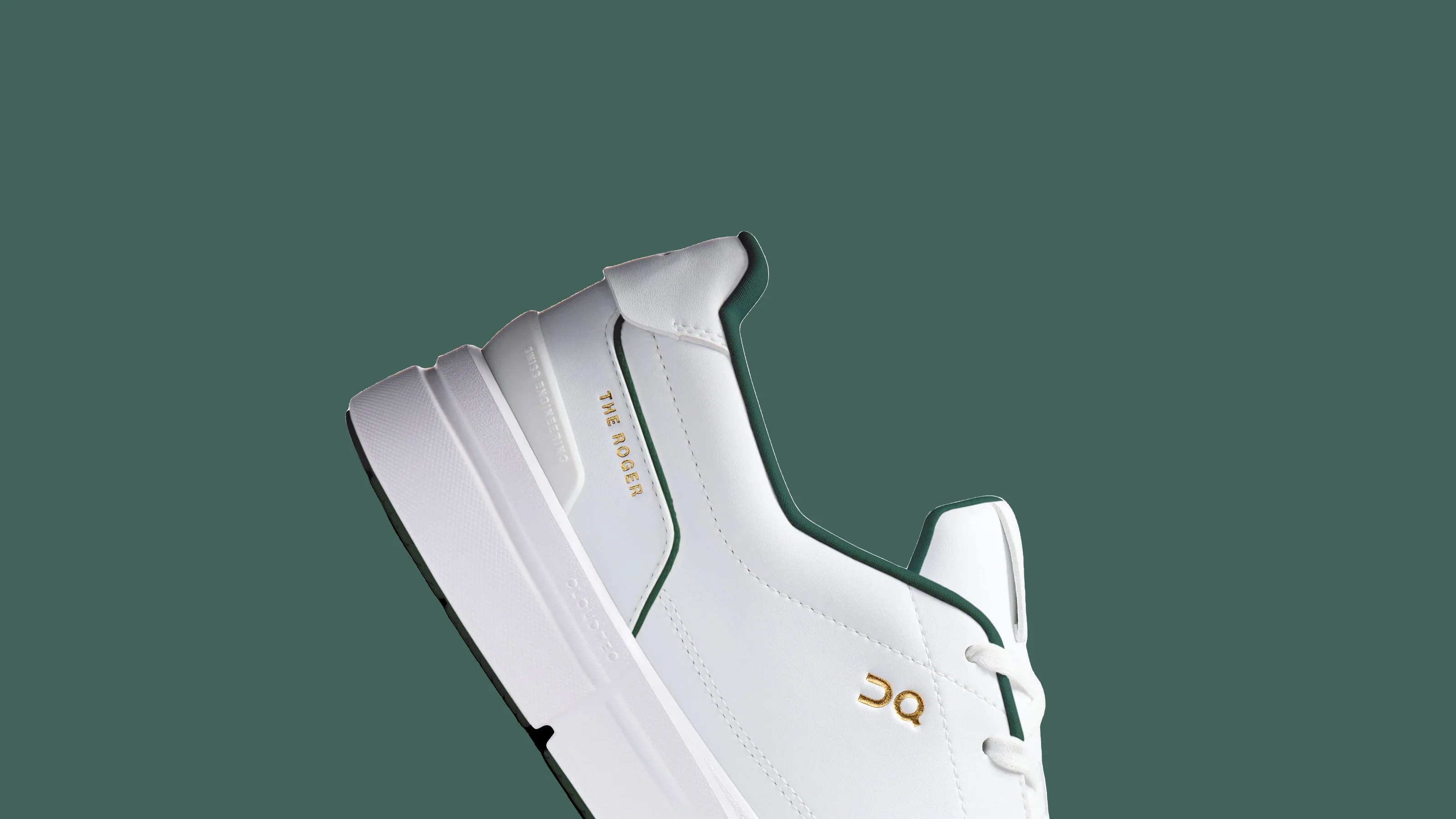 White sneaker with green trim and gold "THE ROGER" text on the side against a green background.