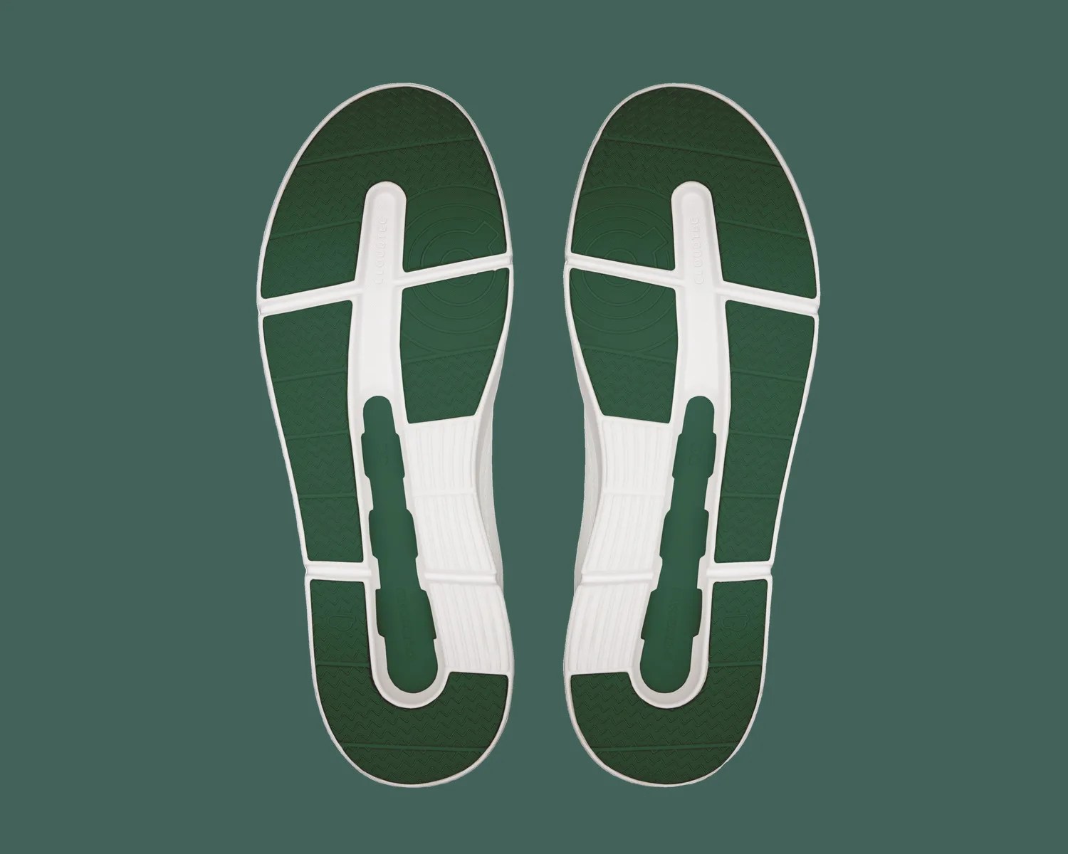 Green and white shoe soles with textured grip pattern on a green background.