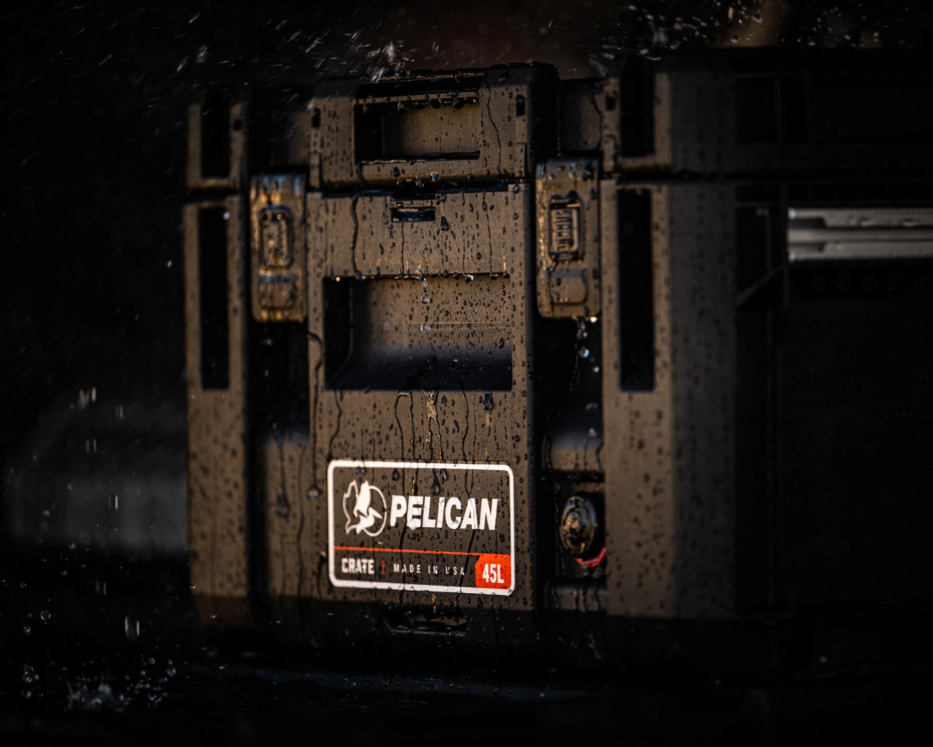 Black Pelican 45L waterproof storage crate with water droplets on its surface.