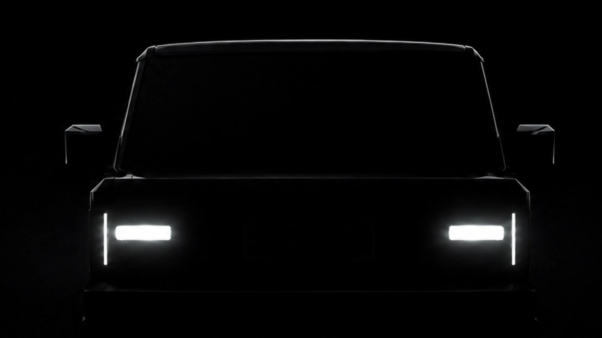 Front view of a vehicle with illuminated rectangular headlights and vertical LED daytime running lights in a dark setting.