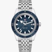 Silver metal bracelet watch with blue bezel and dial, white hour markers, and date window at 3 o'clock.