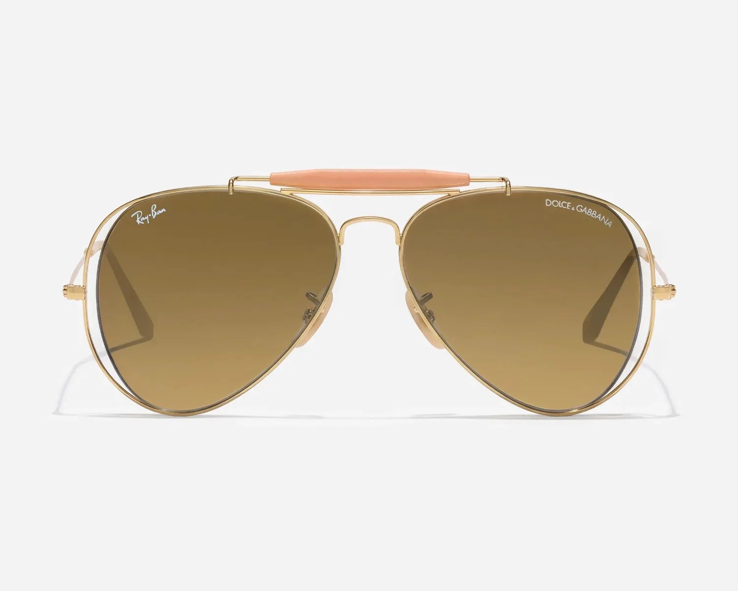 Aviator sunglasses with gold metal frames, brown gradient lenses, and a peach-colored top bar, branded Ray-Ban and Dolce & Gabbana.