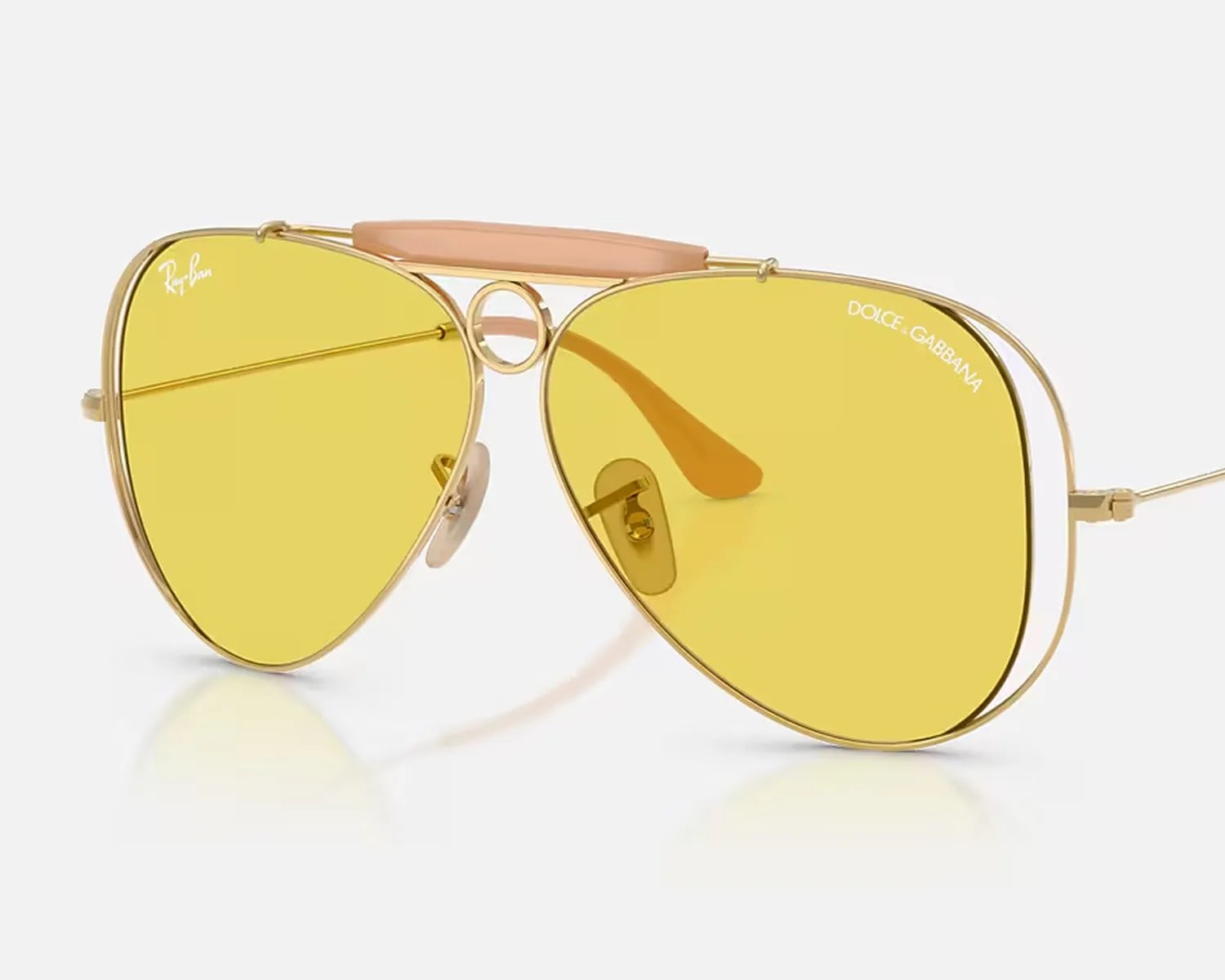 Gold metal aviator sunglasses with yellow lenses, featuring Ray-Ban and Dolce & Gabbana logos.