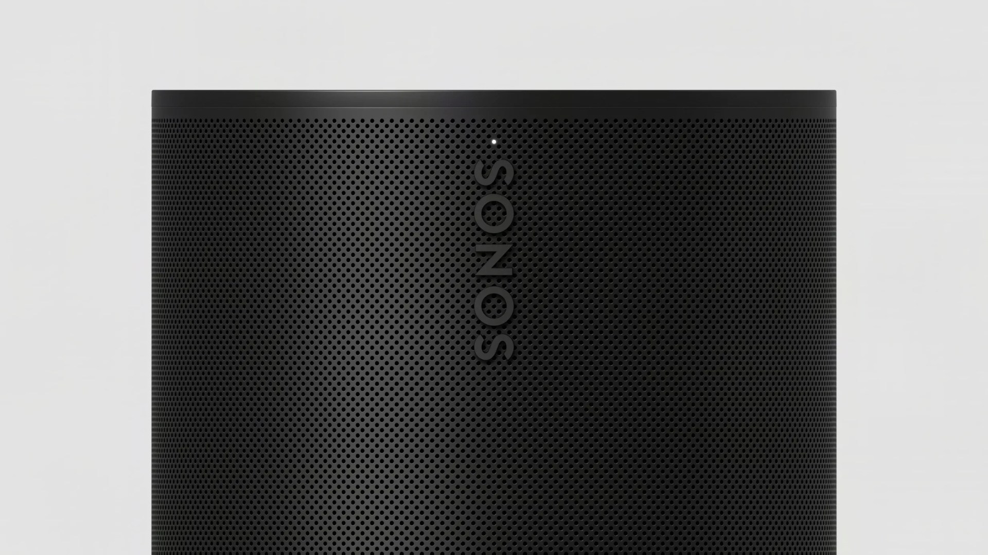 Close-up of a black Sonos speaker grille with perforated holes and a small white indicator light.