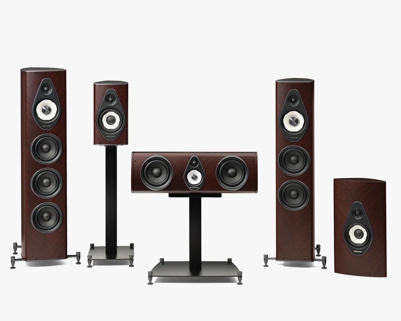 Five-piece dark wood finish speaker set with black and white drivers, including two tall floor-standing speakers, two bookshelf speakers on stands, and one center channel speaker on a stand.
