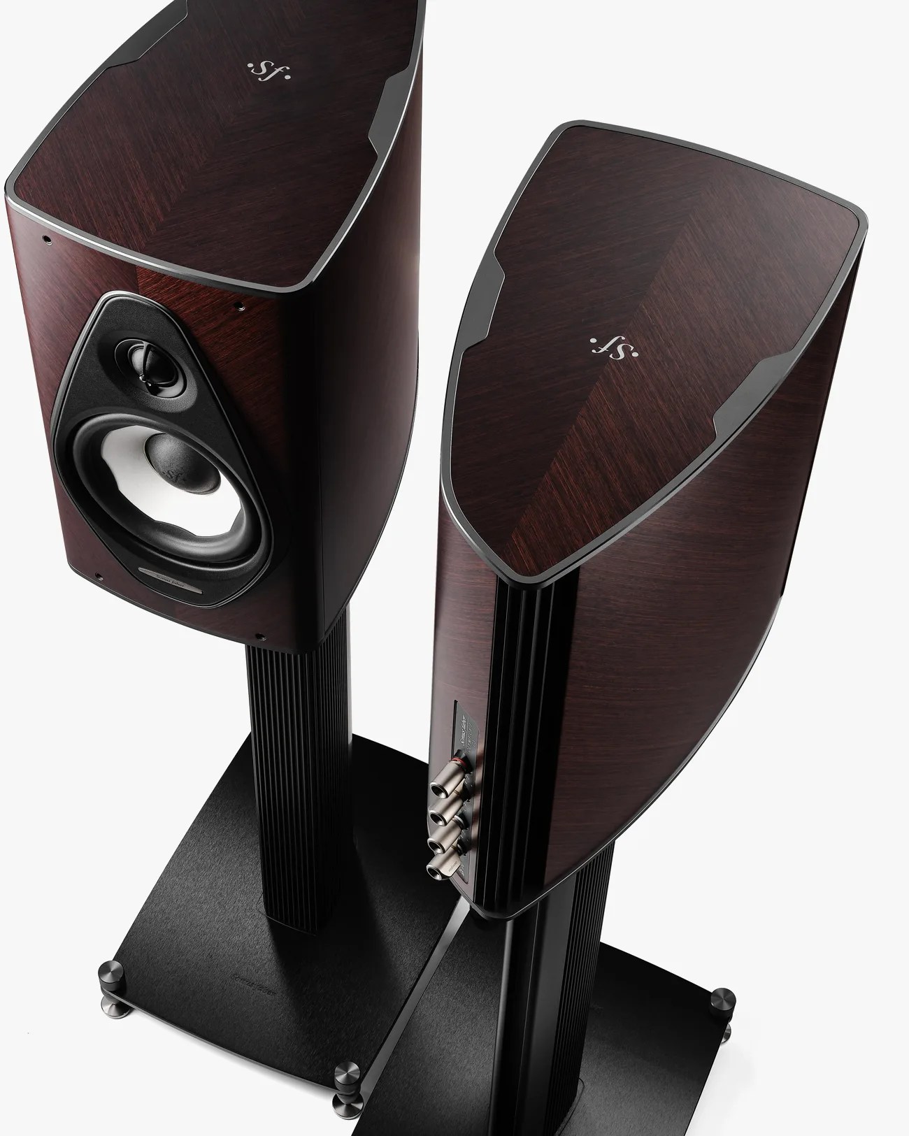 Pair of dark wood-finished bookshelf speakers with black stands and silver connectors on a white background.