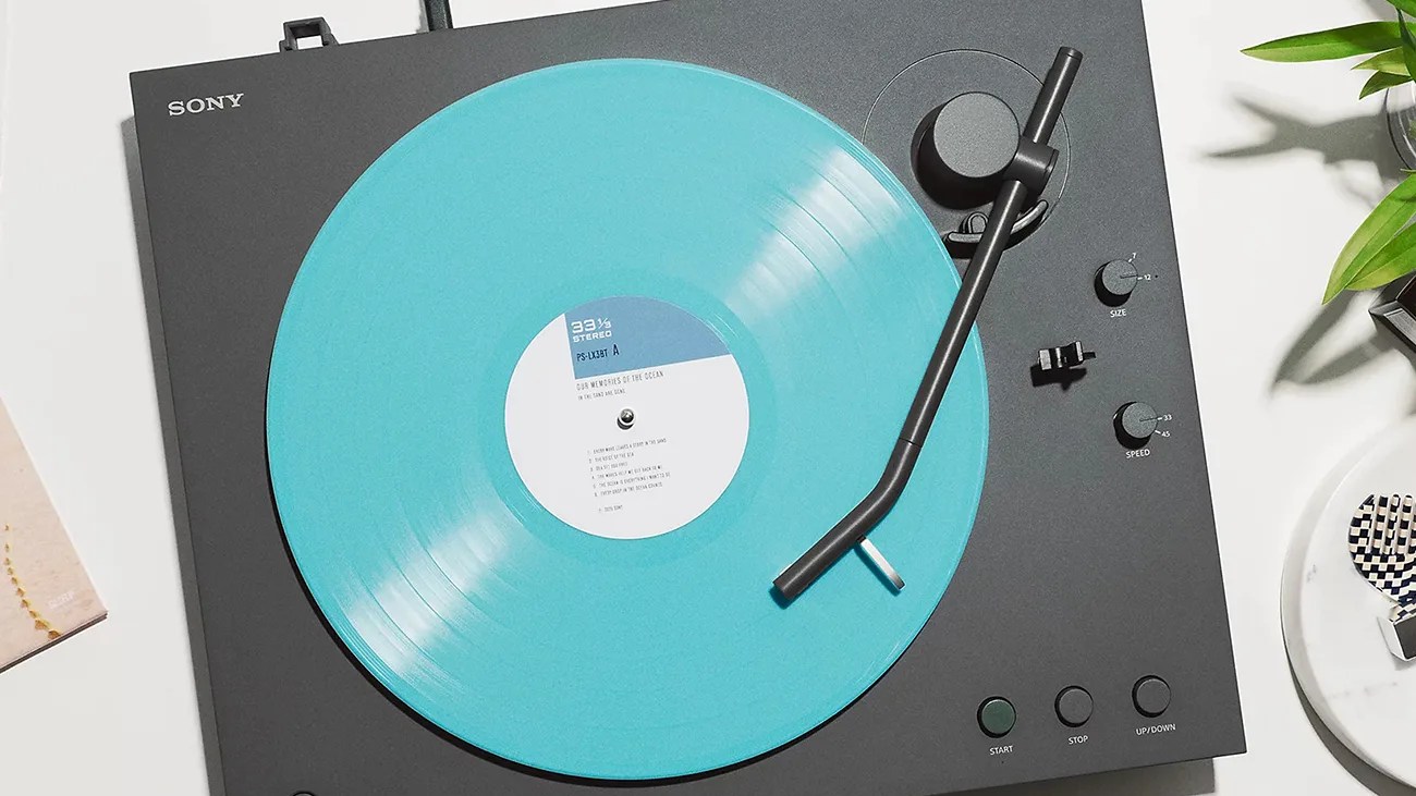 Black Sony turntable playing a turquoise vinyl record with tonearm positioned on the record.