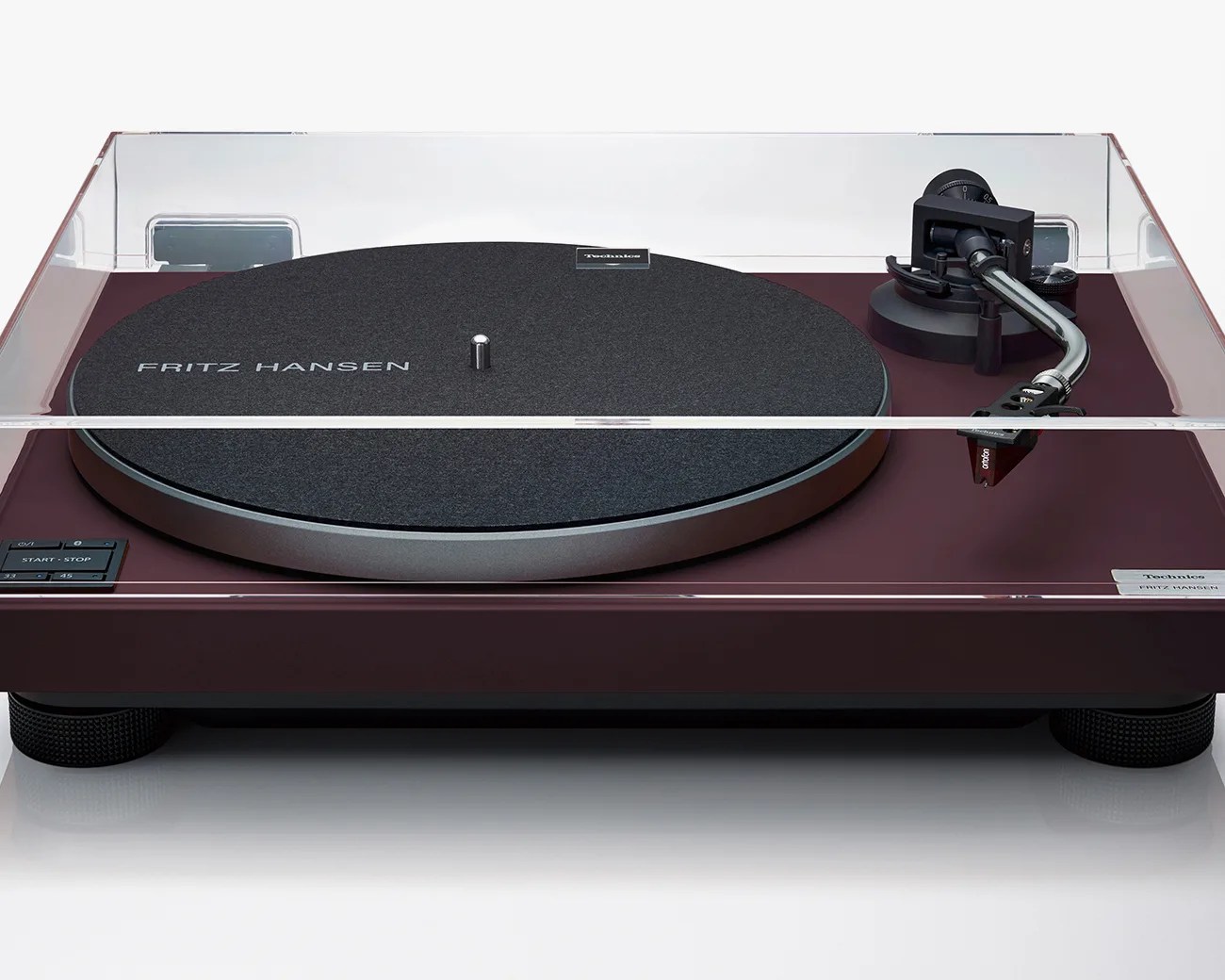 Burgundy Technics turntable with black felt mat labeled "Fritz Hansen" and clear dust cover.