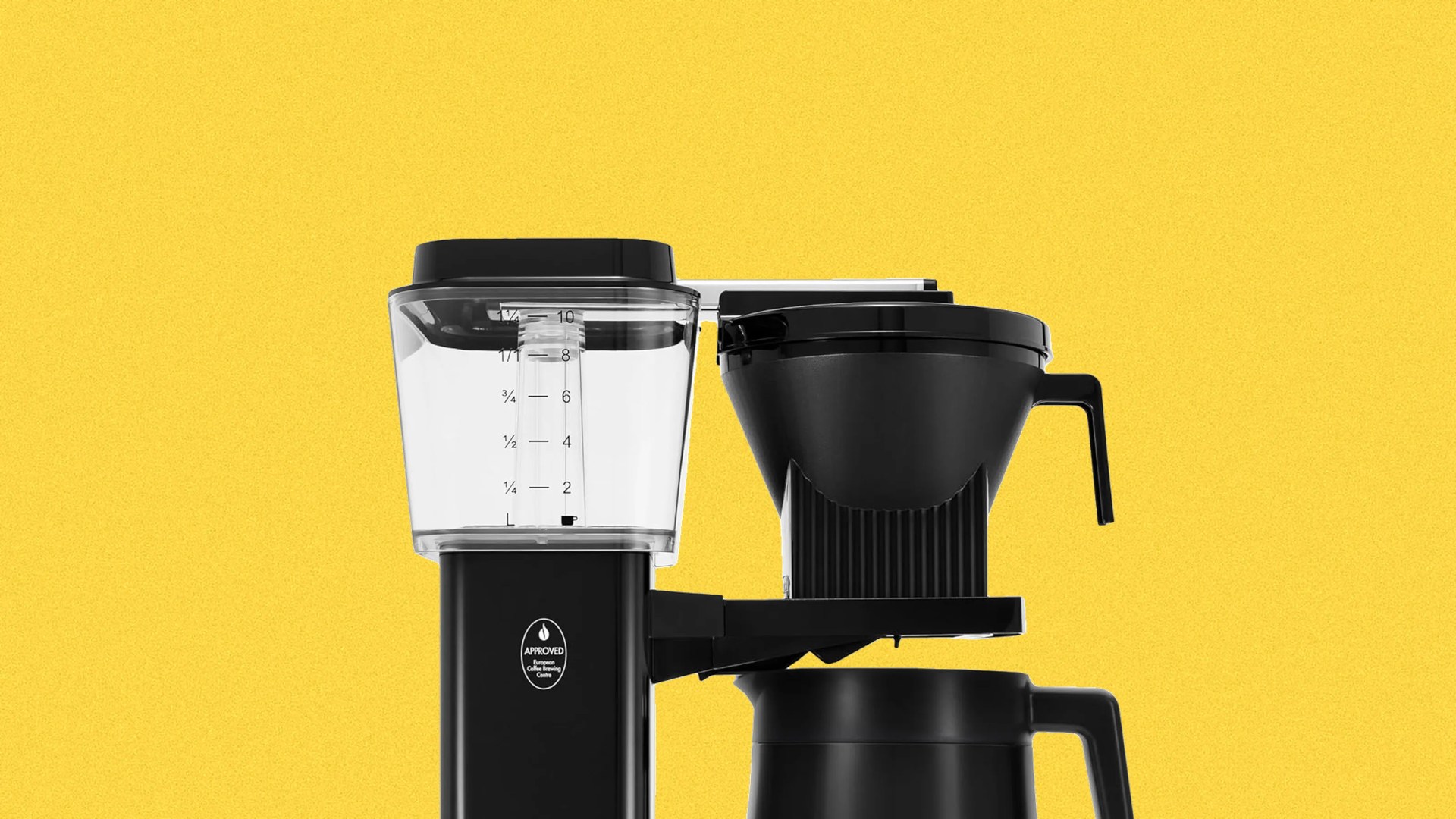Black coffee maker with clear water reservoir and black carafe against a yellow background.