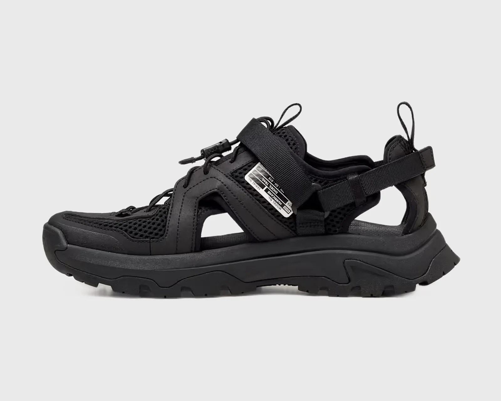 Black sporty sandal with mesh panels, adjustable straps, and thick rugged sole.