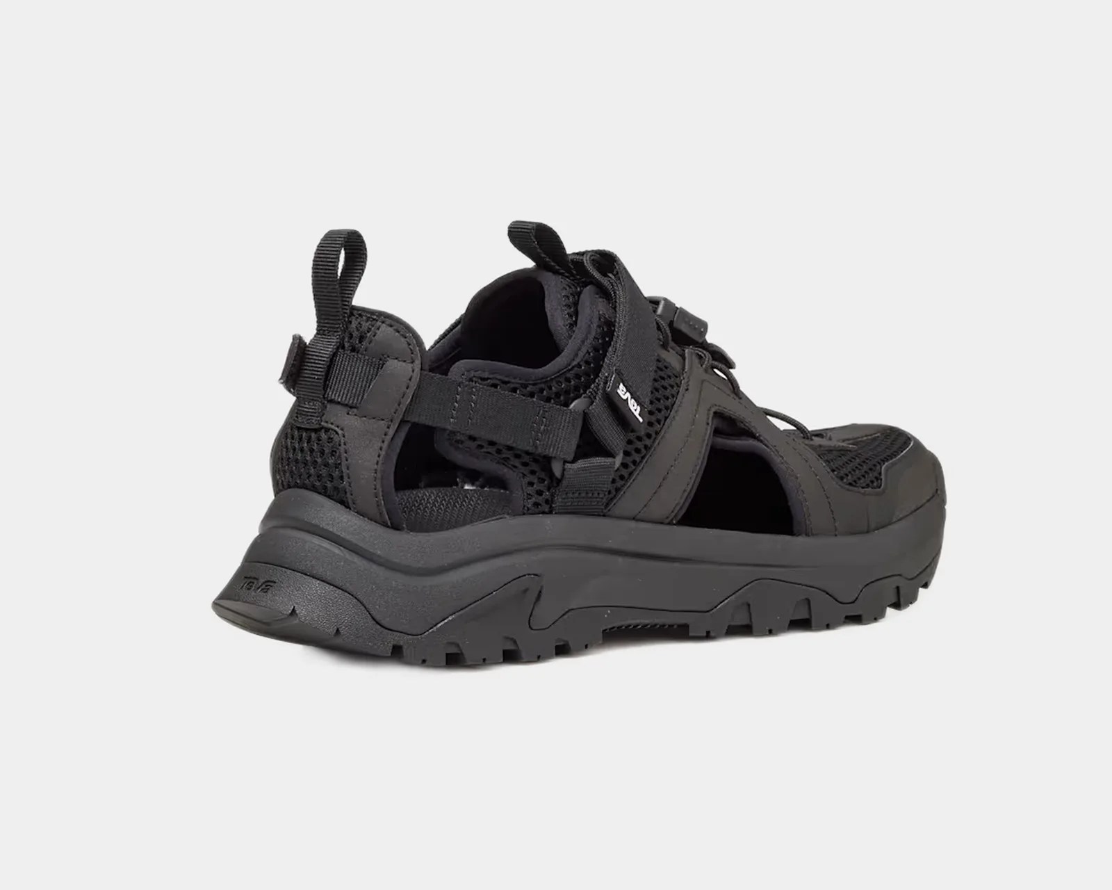 Black rugged outdoor sandal with thick sole and mesh upper, viewed from the side.