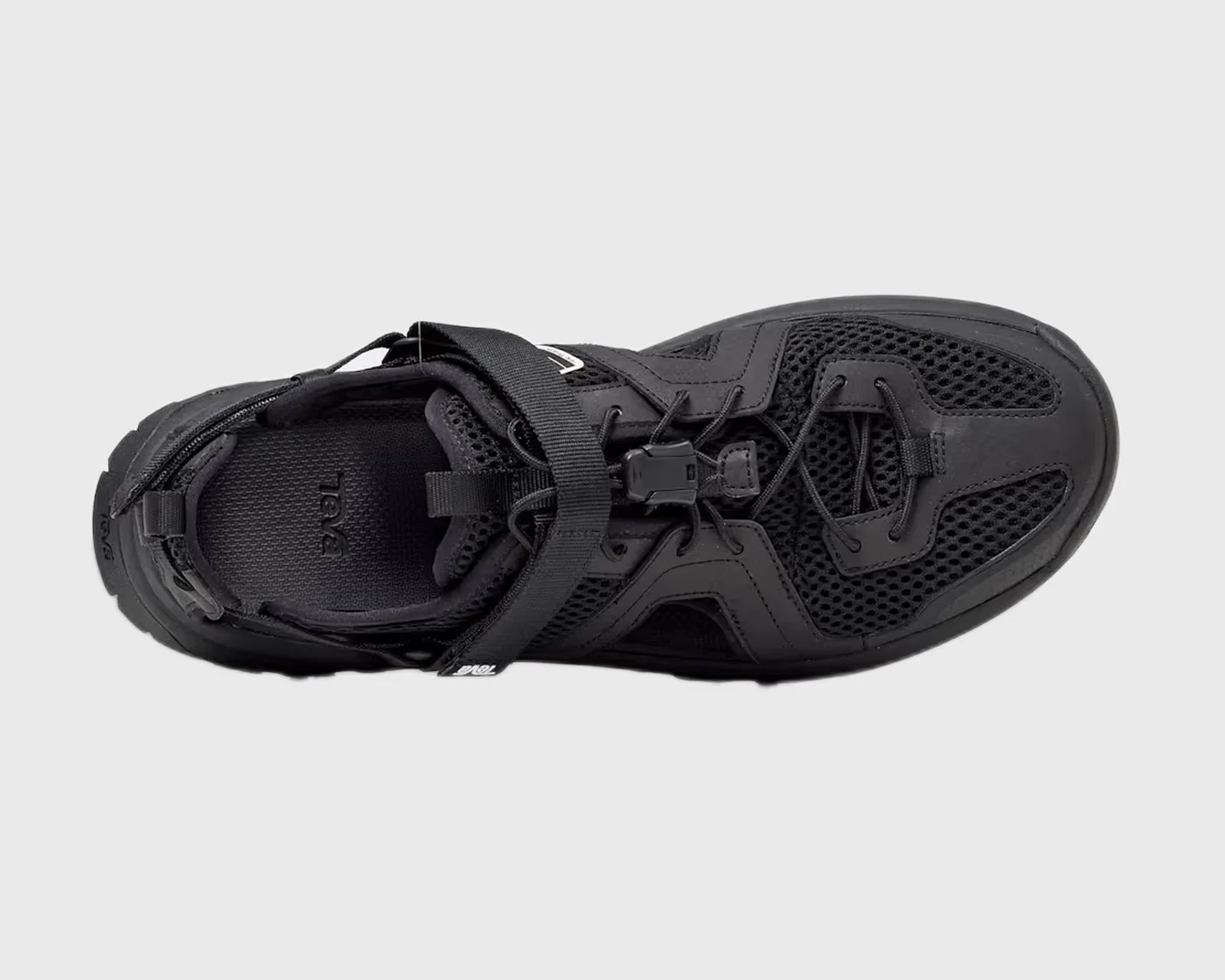 Black athletic shoe with mesh upper, adjustable strap, and bungee laces viewed from above.