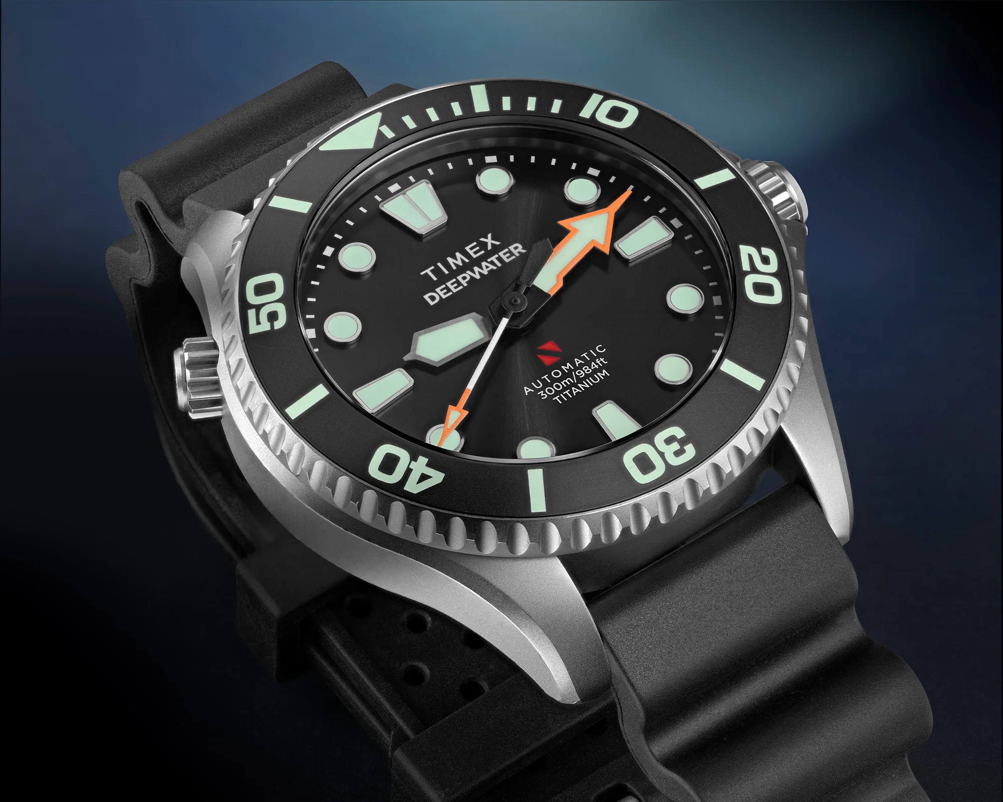 Close-up of a Timex Deepwater automatic titanium dive watch with black dial, luminous markers, and black rubber strap.