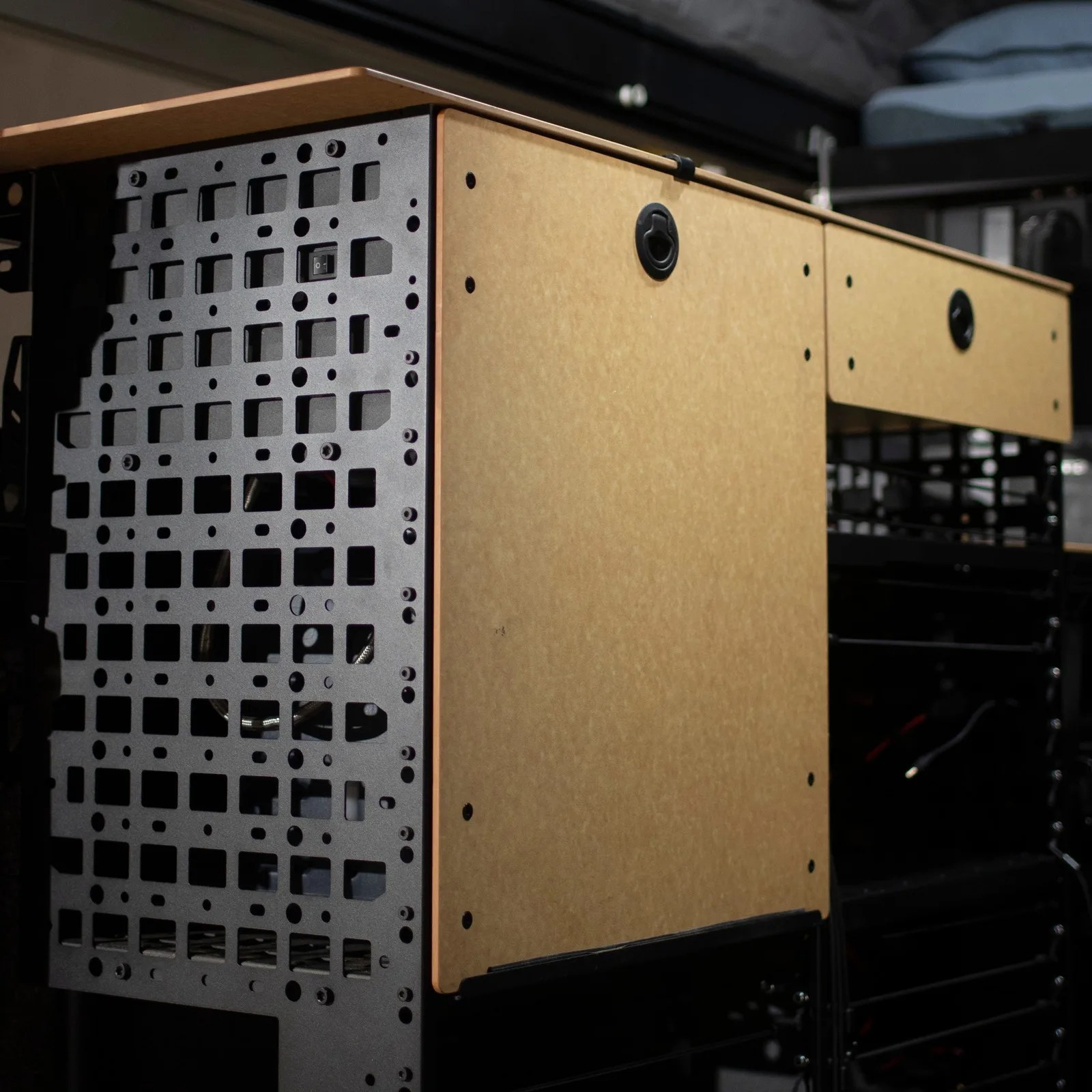 Black metal computer case frame with beige wooden side panels and a power switch.