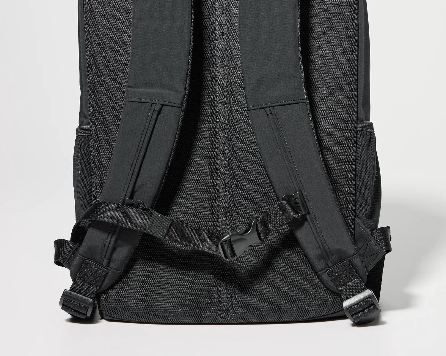 Black padded backpack straps with adjustable buckles and a chest strap on a black mesh back panel.