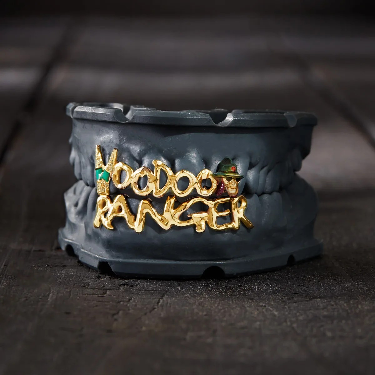 Dark gray dental mold with gold and green "Voodoo Ranger" grillz featuring a skull with a green hat and sunglasses.