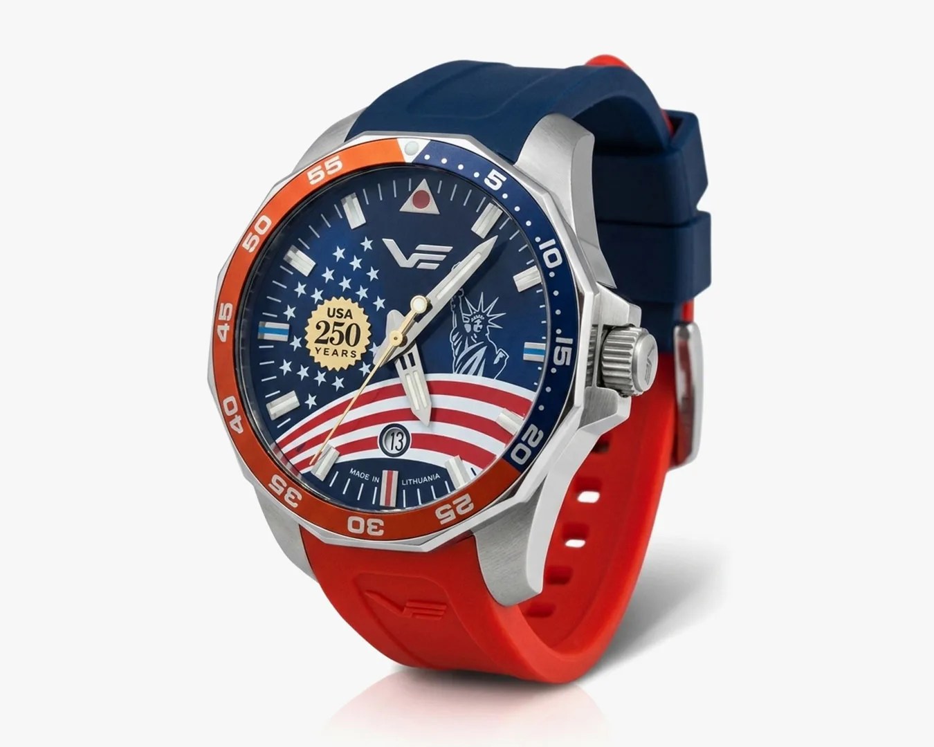 Silver watch with blue and orange bezel, blue dial featuring USA 250 years emblem, Statue of Liberty, and red and white striped silicone strap.