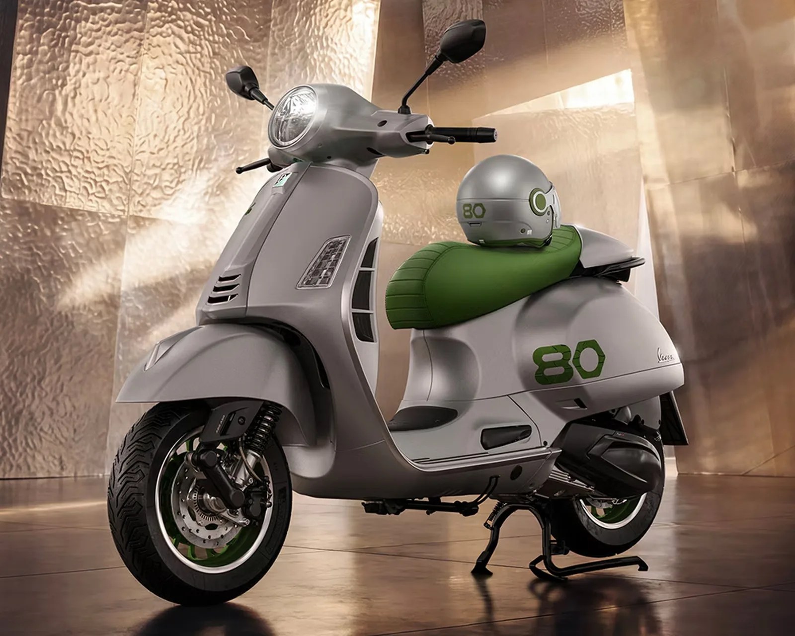 Silver Vespa scooter with green seat and matching helmet, featuring the number 80 on the side and helmet.