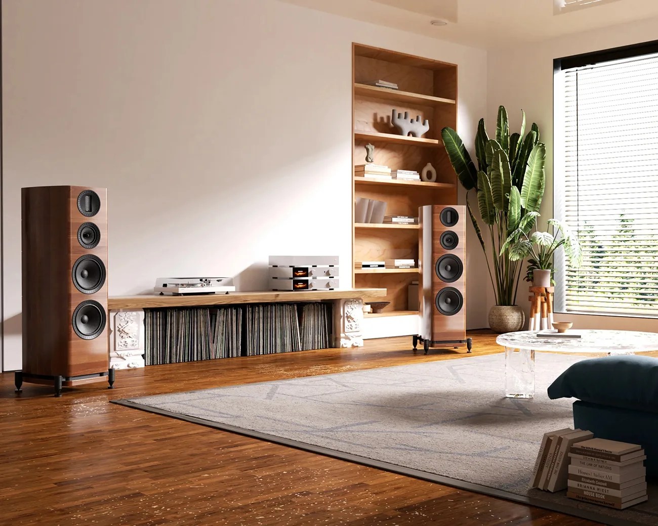 Modern living room with wooden floor, large floor-standing speakers, built-in wooden shelves, and a round marble coffee table.