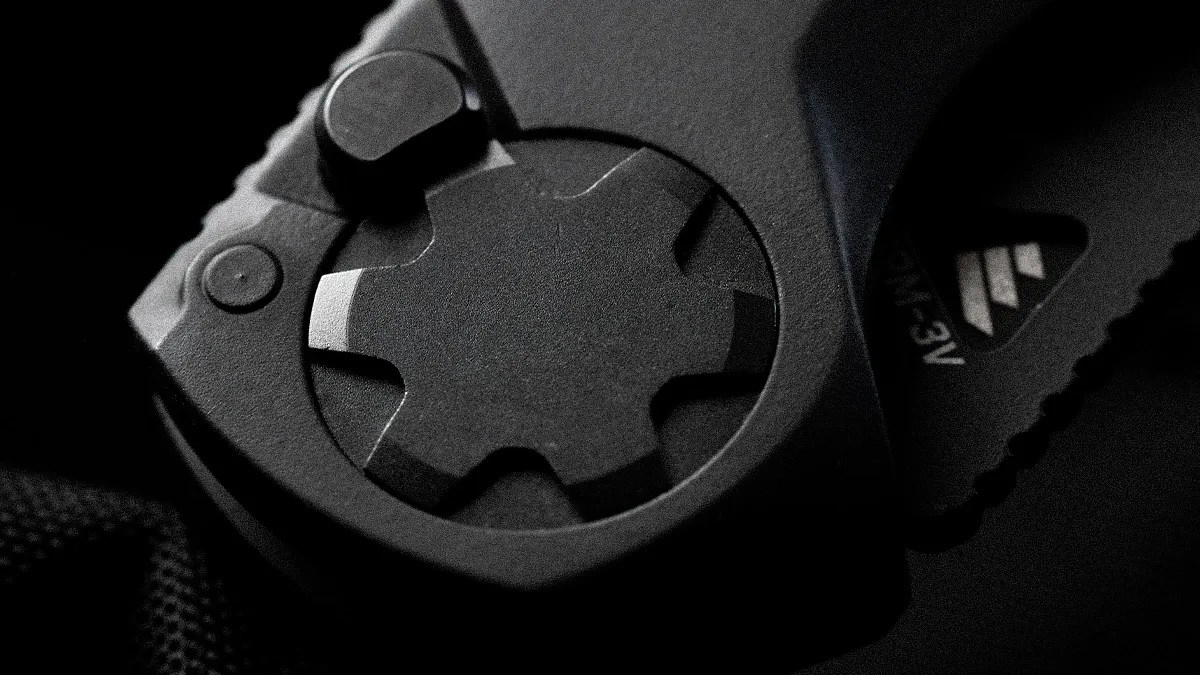 Close-up of a black mechanical dial with a star-shaped knob and textured grip.