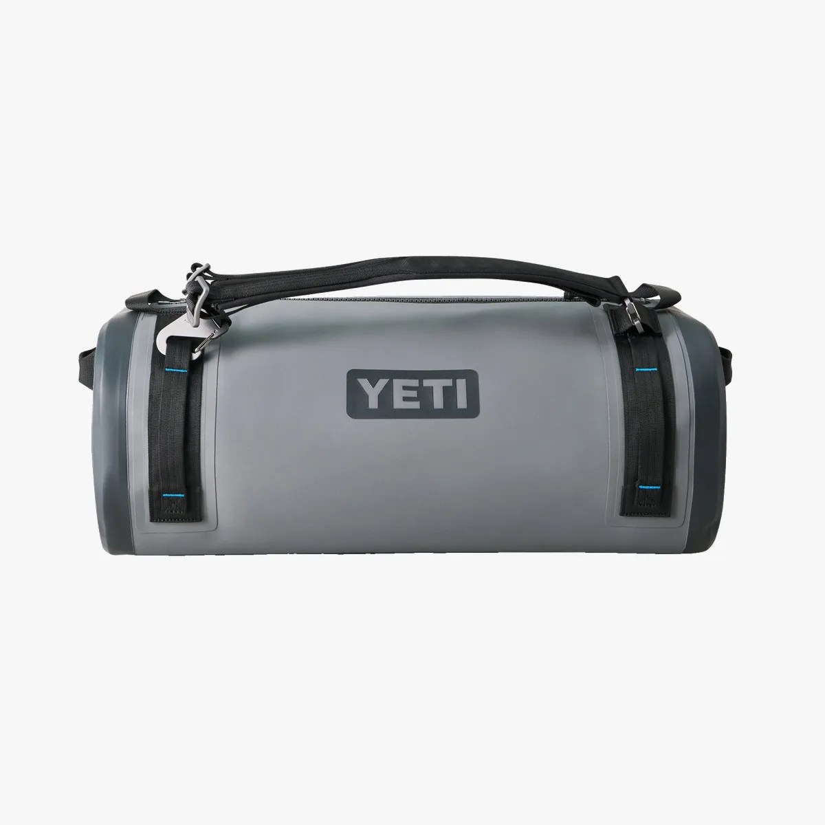 Gray cylindrical YETI cooler bag with black adjustable shoulder strap and blue stitching.