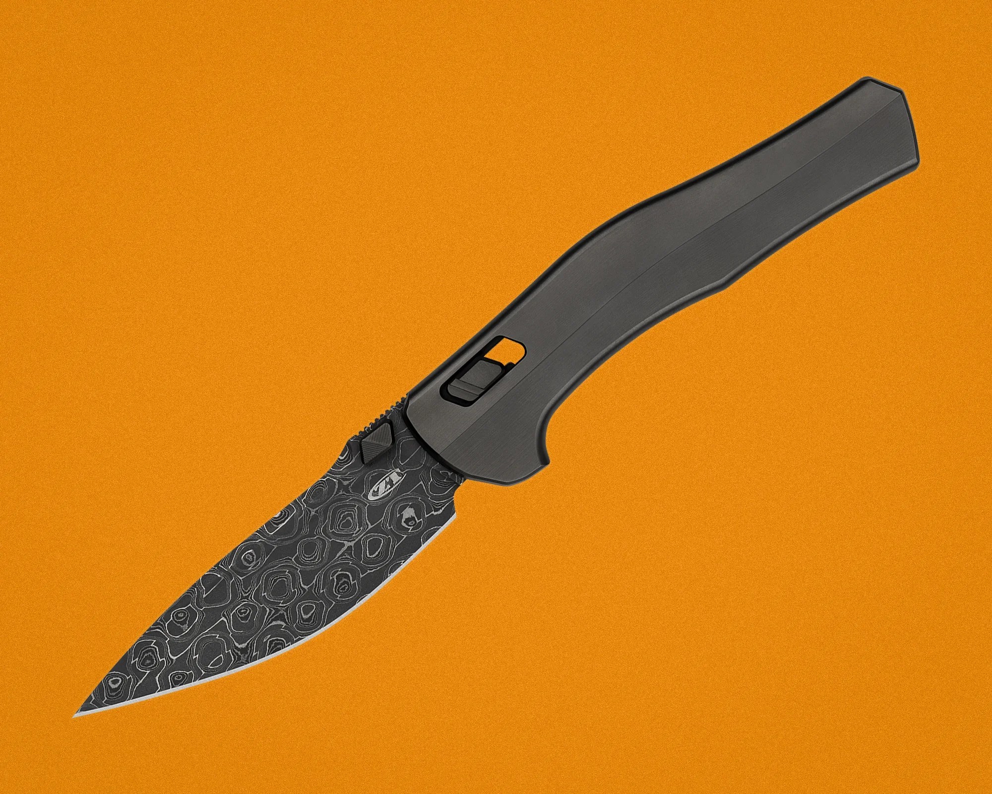 Black folding knife with patterned blade and textured handle on an orange background.