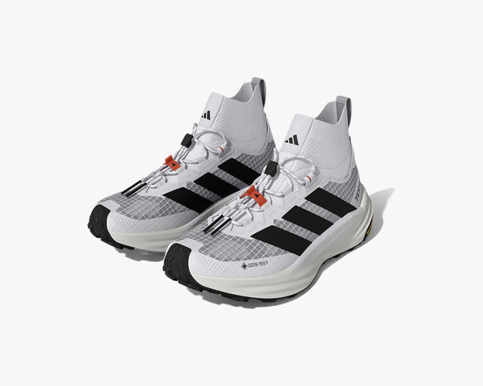 Pair of white Adidas high-top sneakers with black stripes, gray mesh, and orange lace accents.