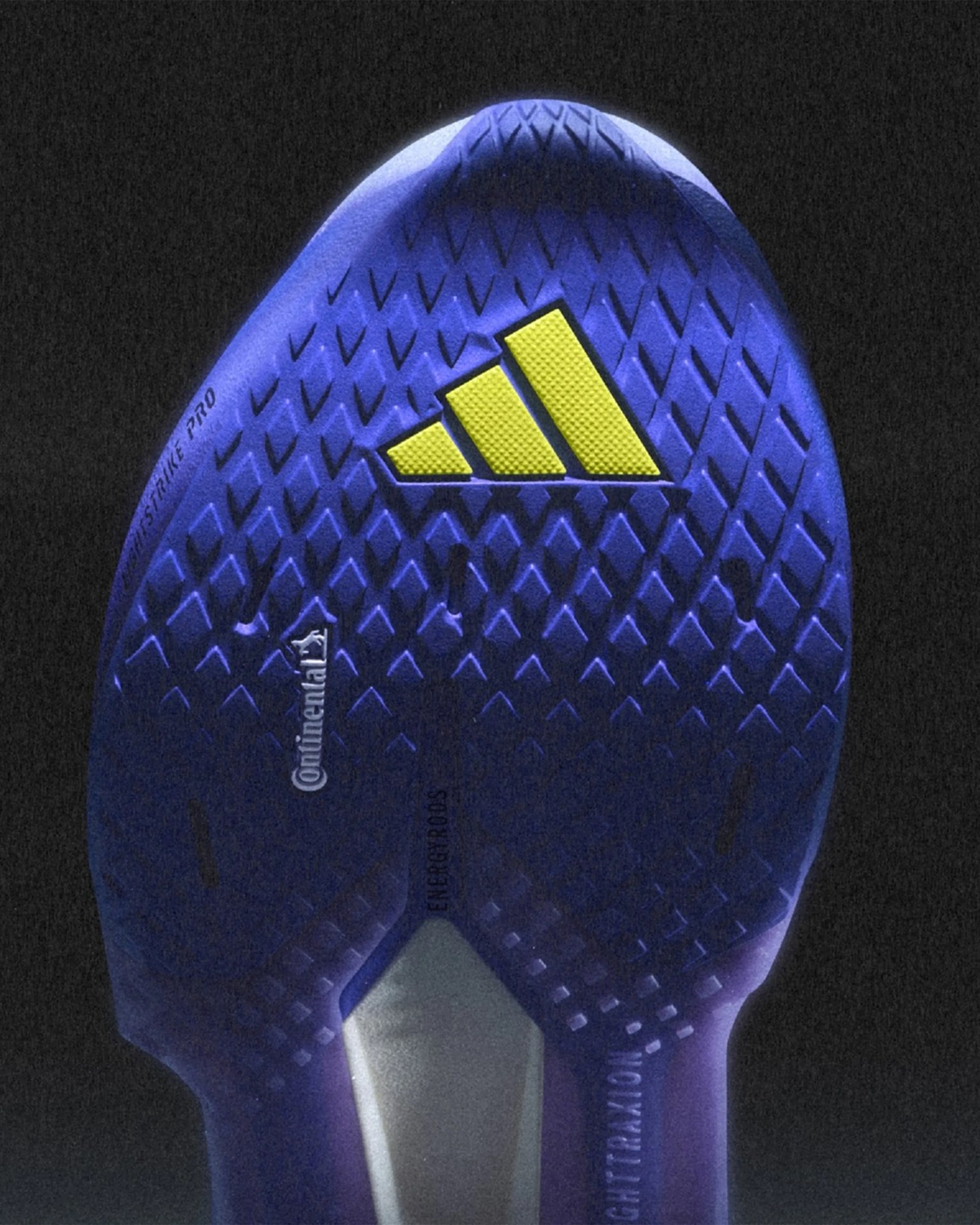 Purple textured sole of an Adidas shoe with a yellow Adidas logo and Continental branding.