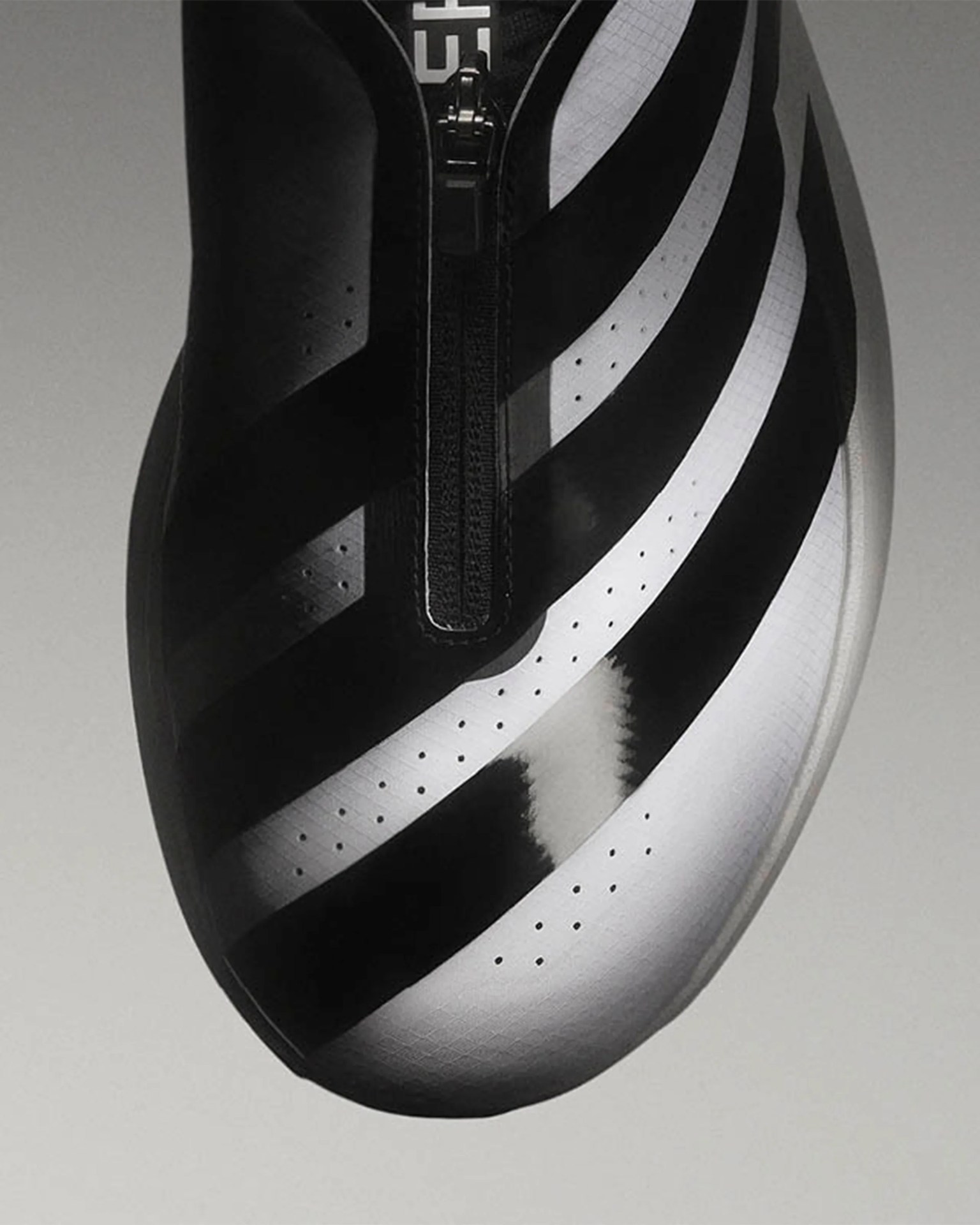 Black and white cycling shoe with a front zipper and perforated upper surface.