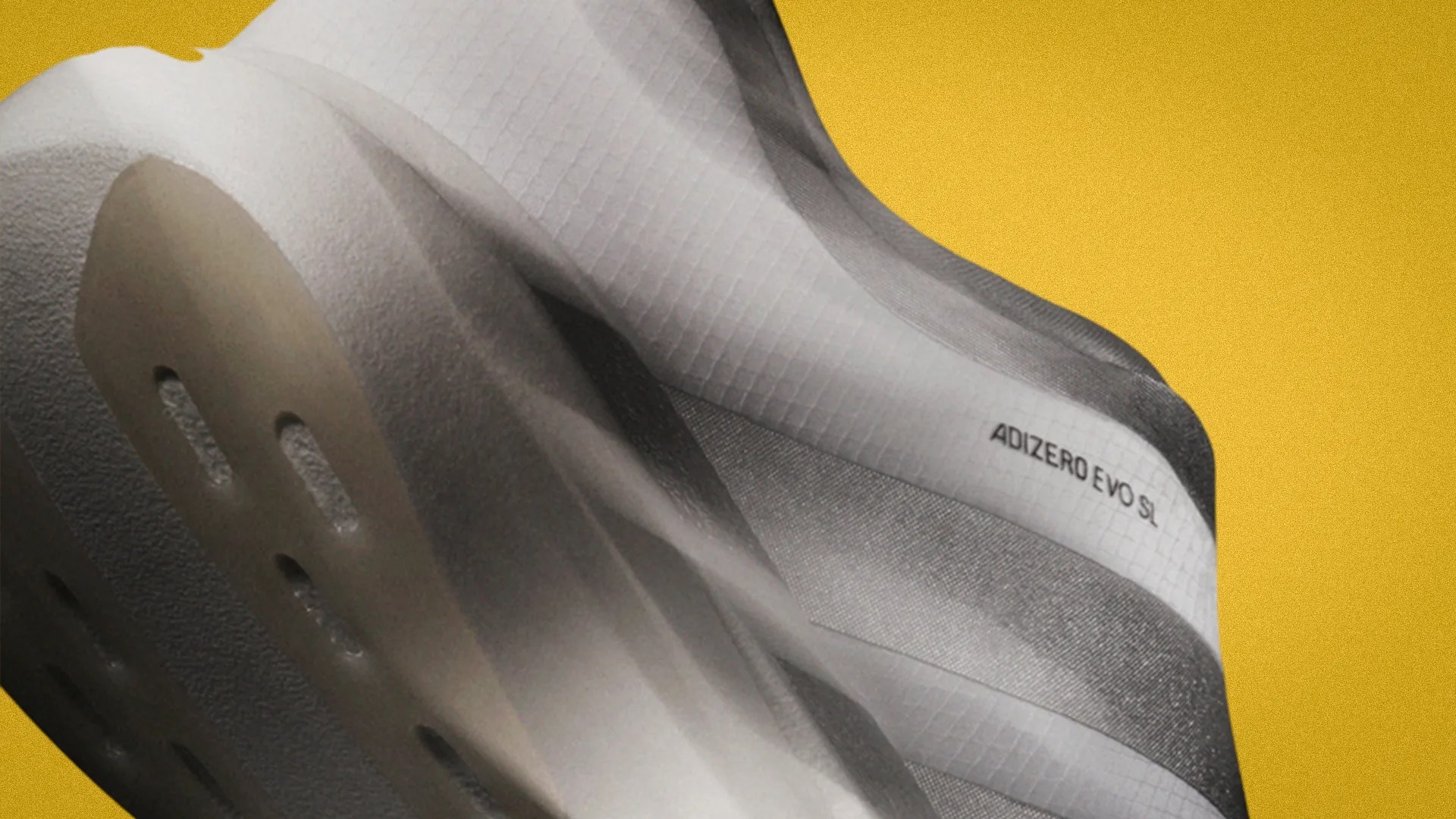 Close-up of a gray and white Adidas Adizero Evo SL shoe sole against a yellow background.