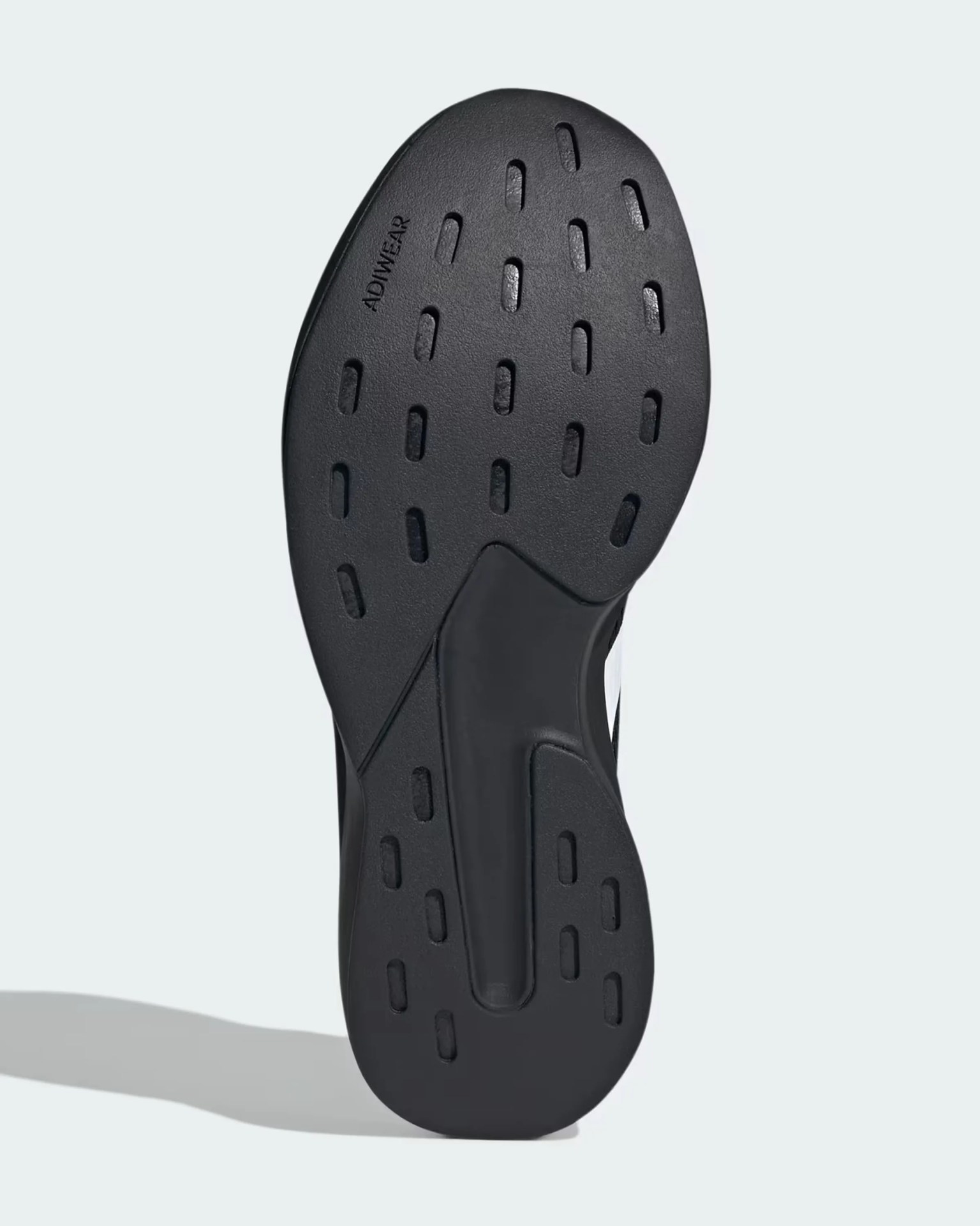 Black shoe sole with rectangular grip patterns and "ADIWEAR" branding near the toe.