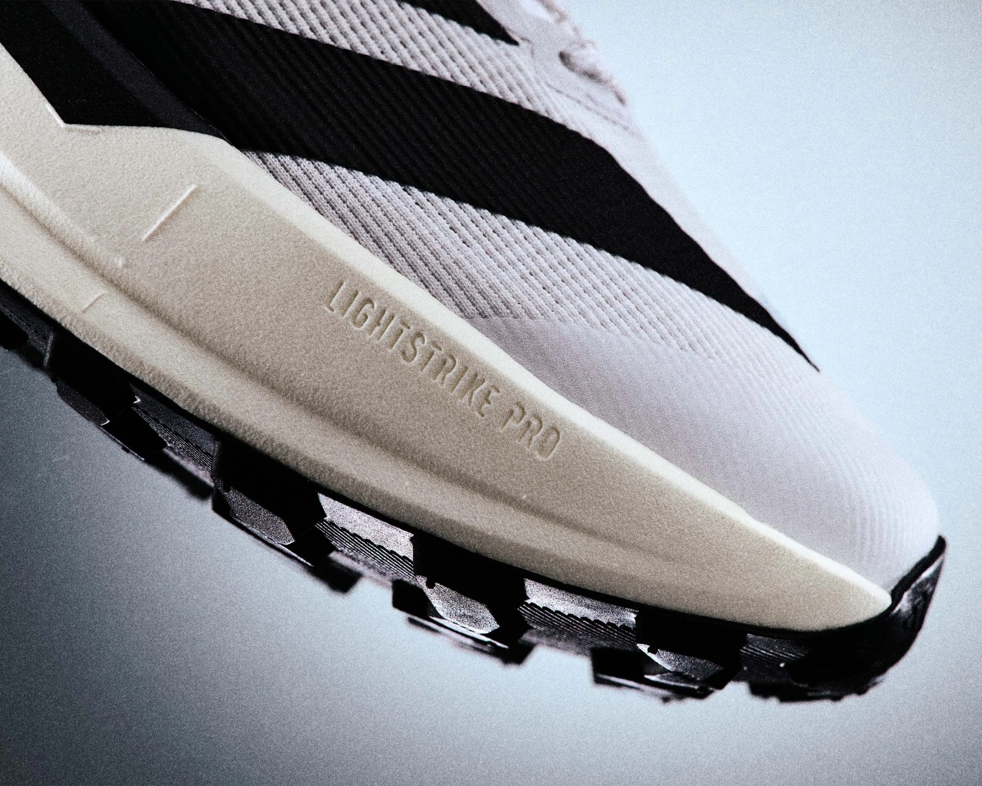Close-up of a white and black sneaker sole with "LIGHTSTRIKE PRO" embossed on the midsole.