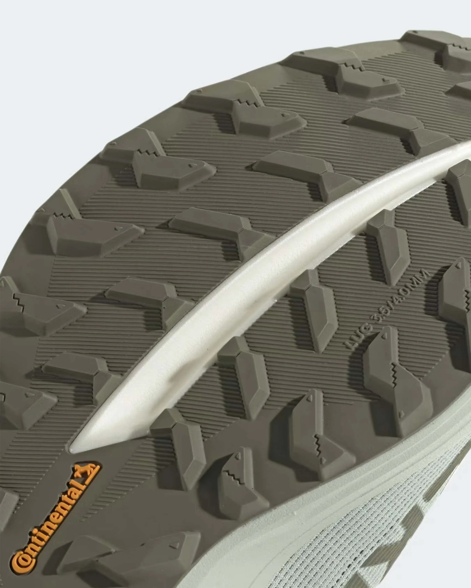 Close-up of a gray Continental rubber shoe sole with rugged tread pattern and white midsole.