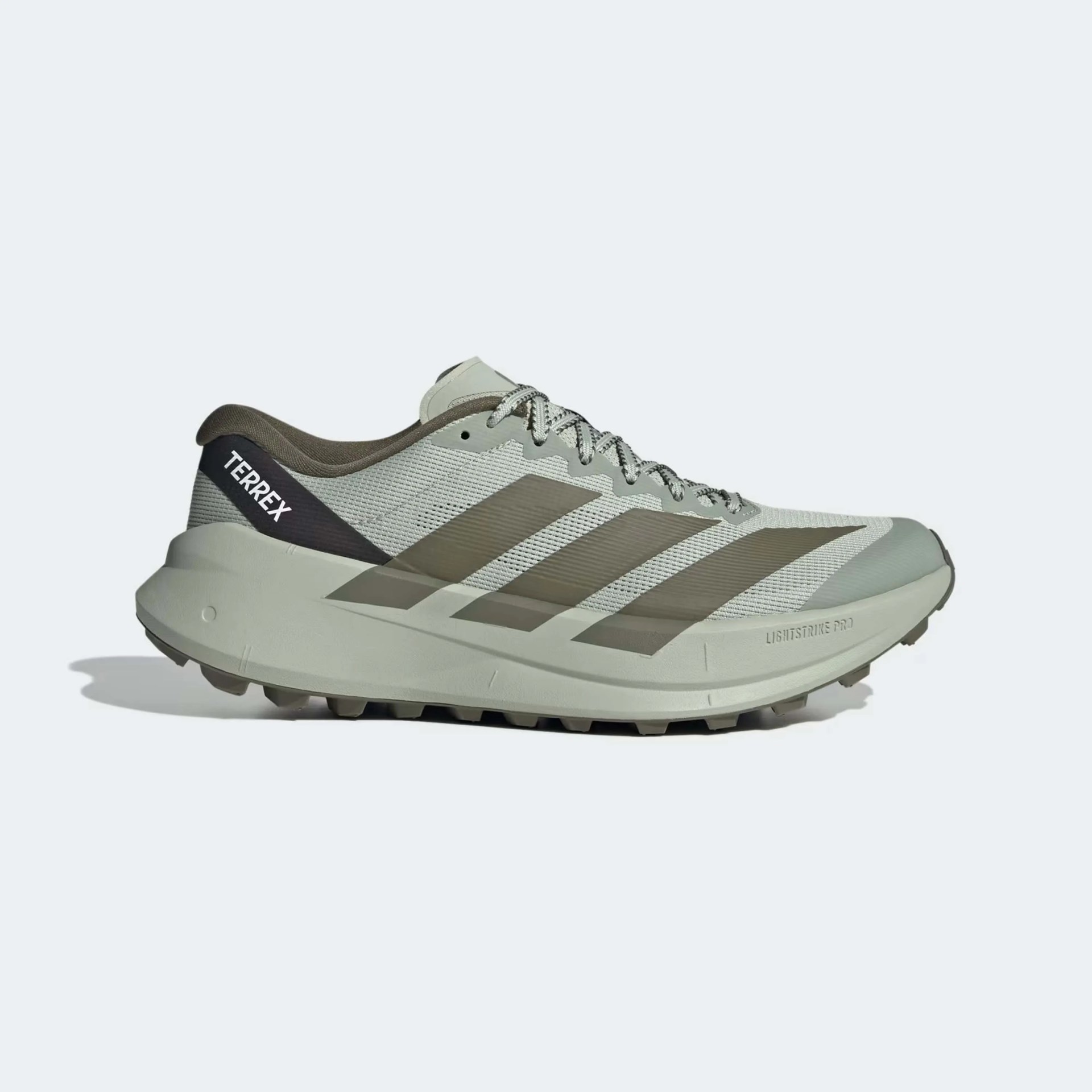 Light gray and olive green Adidas Terrex trail running shoe with black heel tab and rugged sole.