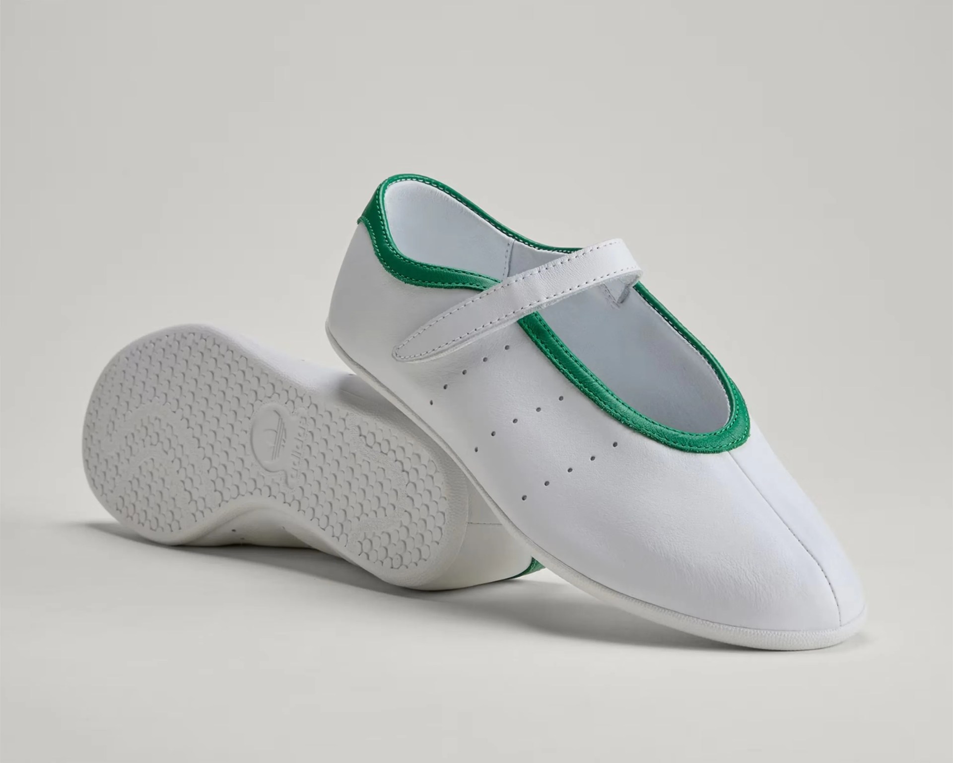White leather Mary Jane shoe with green trim and textured sole, shown from side and bottom angles.
